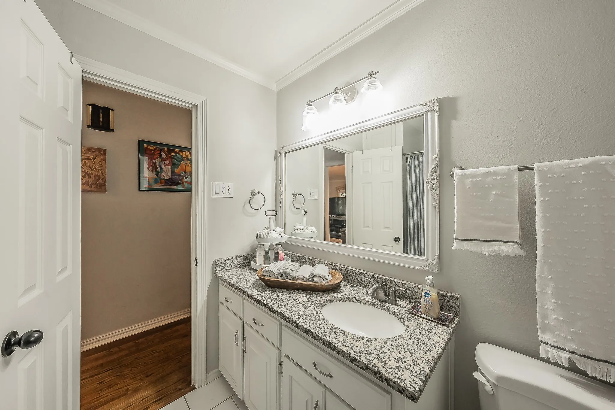 Bathroom featuring a vanity with a granite countertop, undermount sink, and brushed nickel faucet