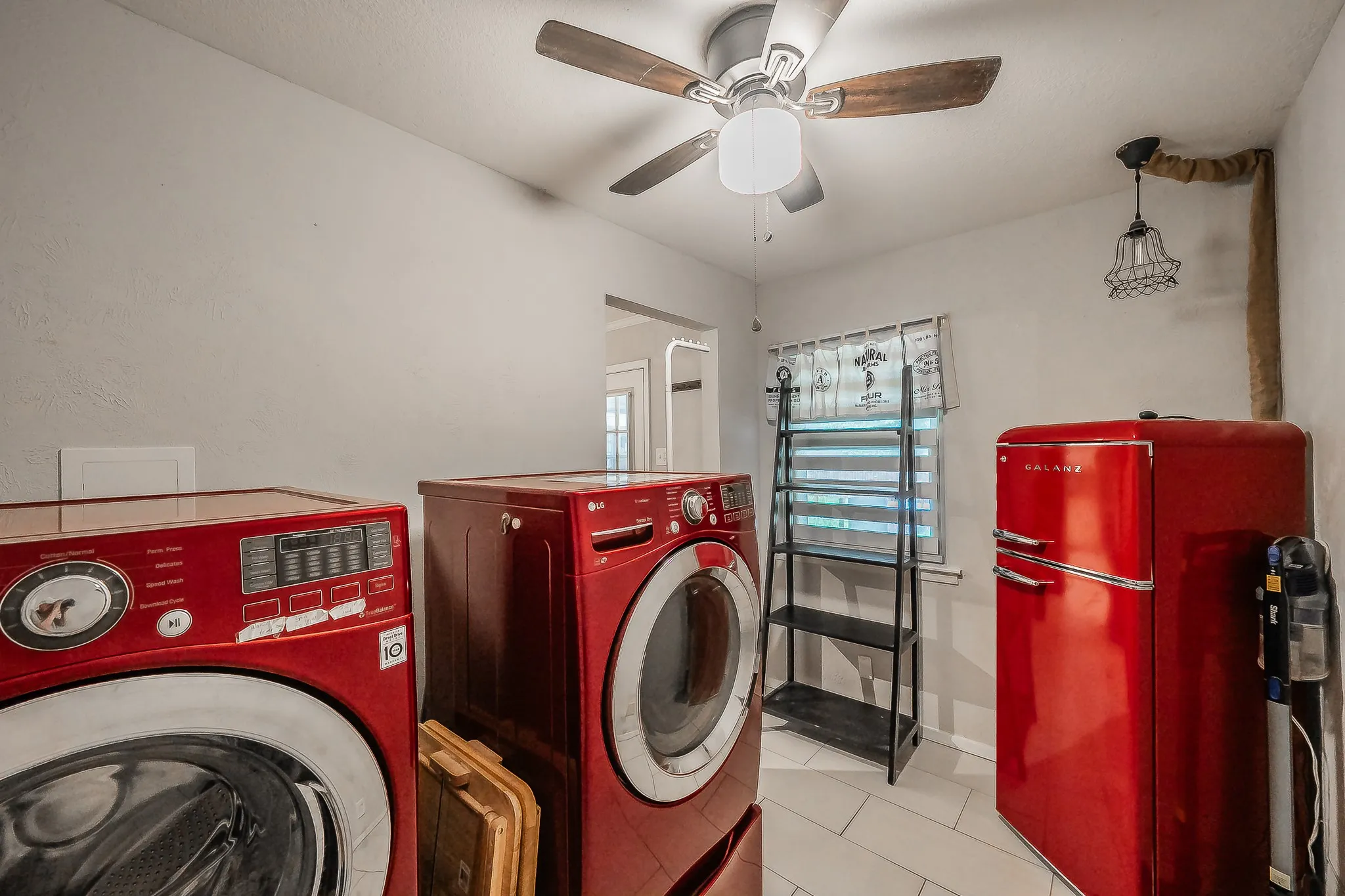 Utility room with tiled flooring and a ceiling fan light fixture