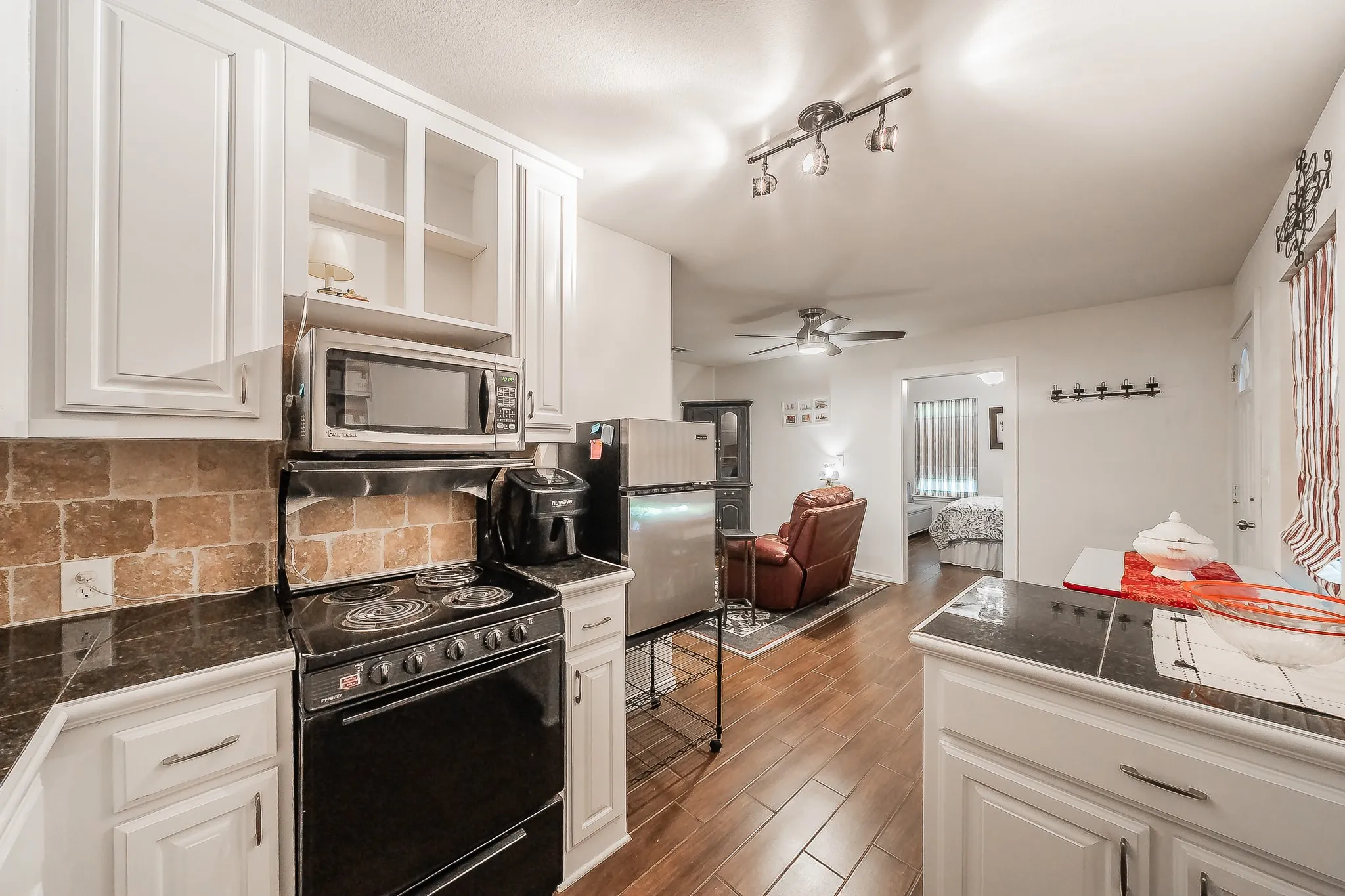 Mother In Law Suite - Kitchen featuring white cabinetry, dark stone countertops, and a subway tile backsplash