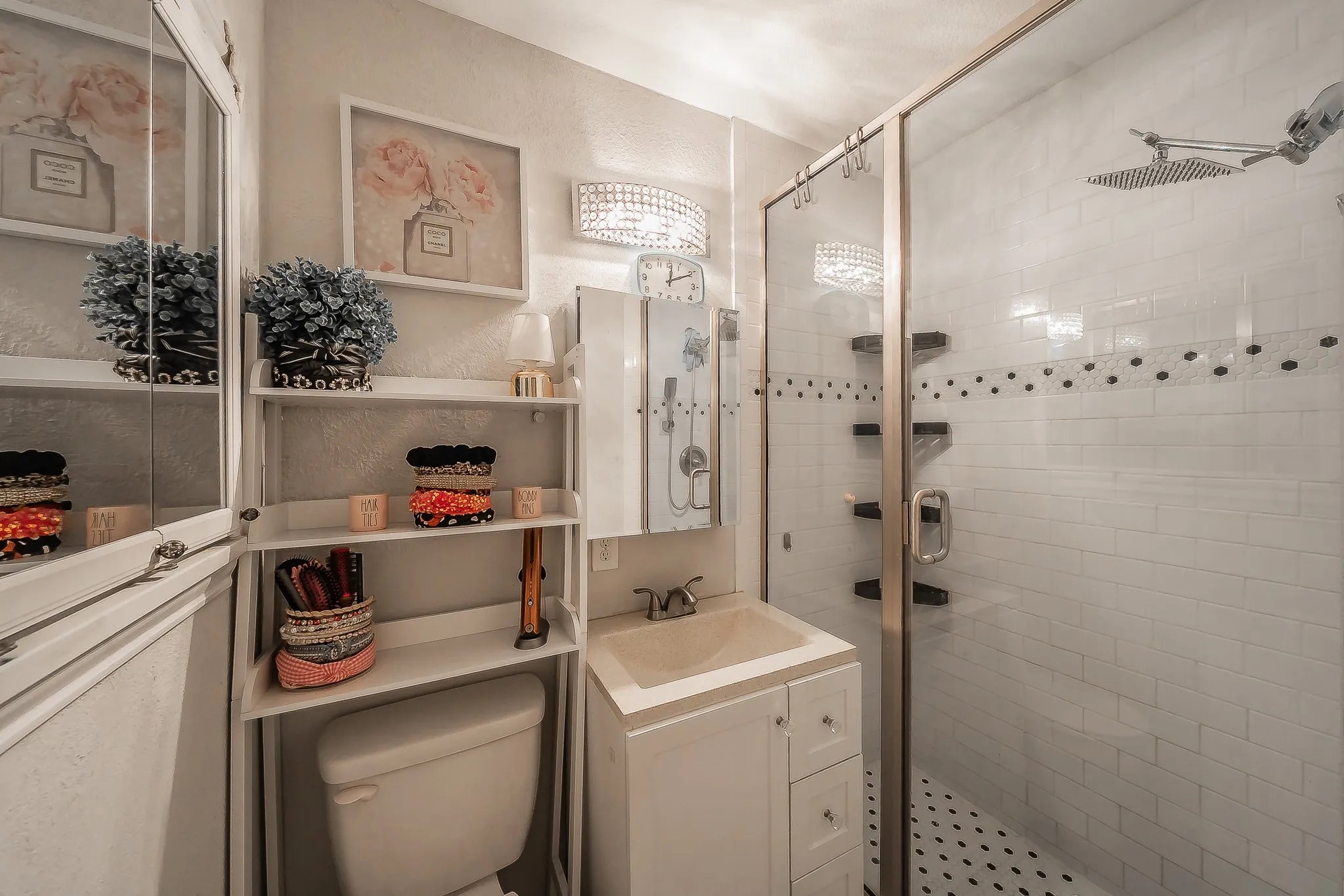 Full bathroom featuring a glass-enclosed shower with subway tile surround and built-in shelving