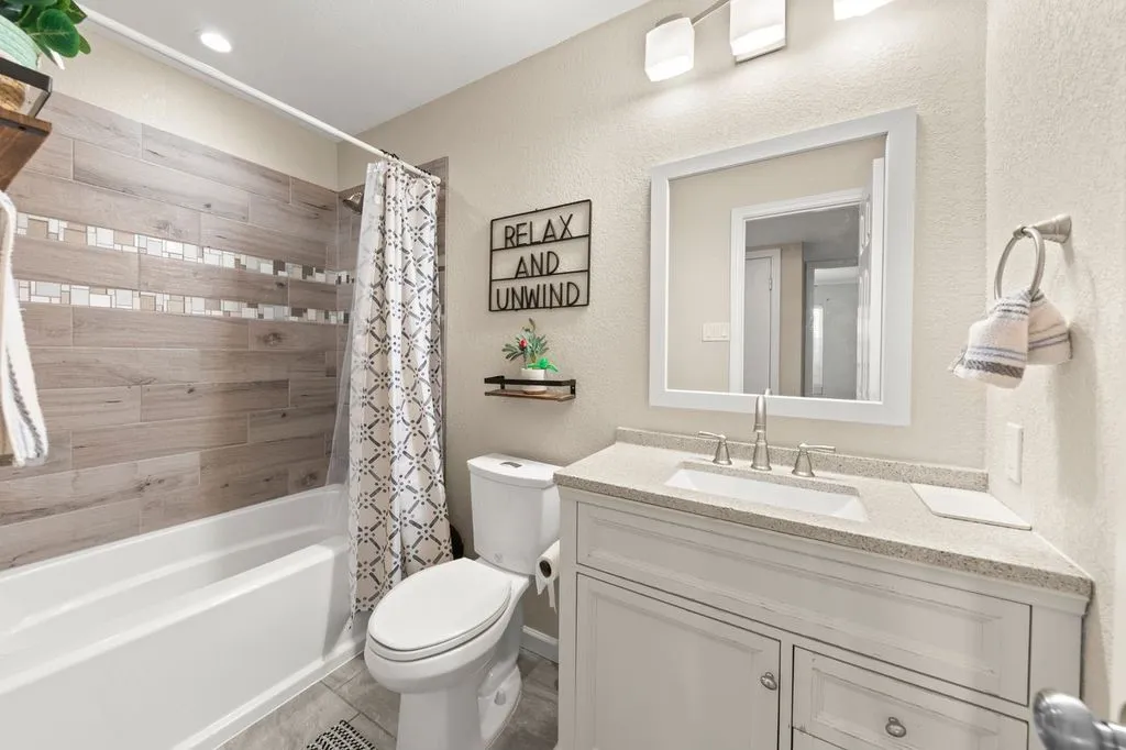 Bathroom featuring a white vanity with a stone-finish countertop, integrated sink, and brushed nickel faucet