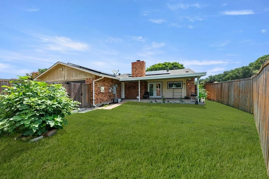 Expansive green lawn with a wood fence perimeter