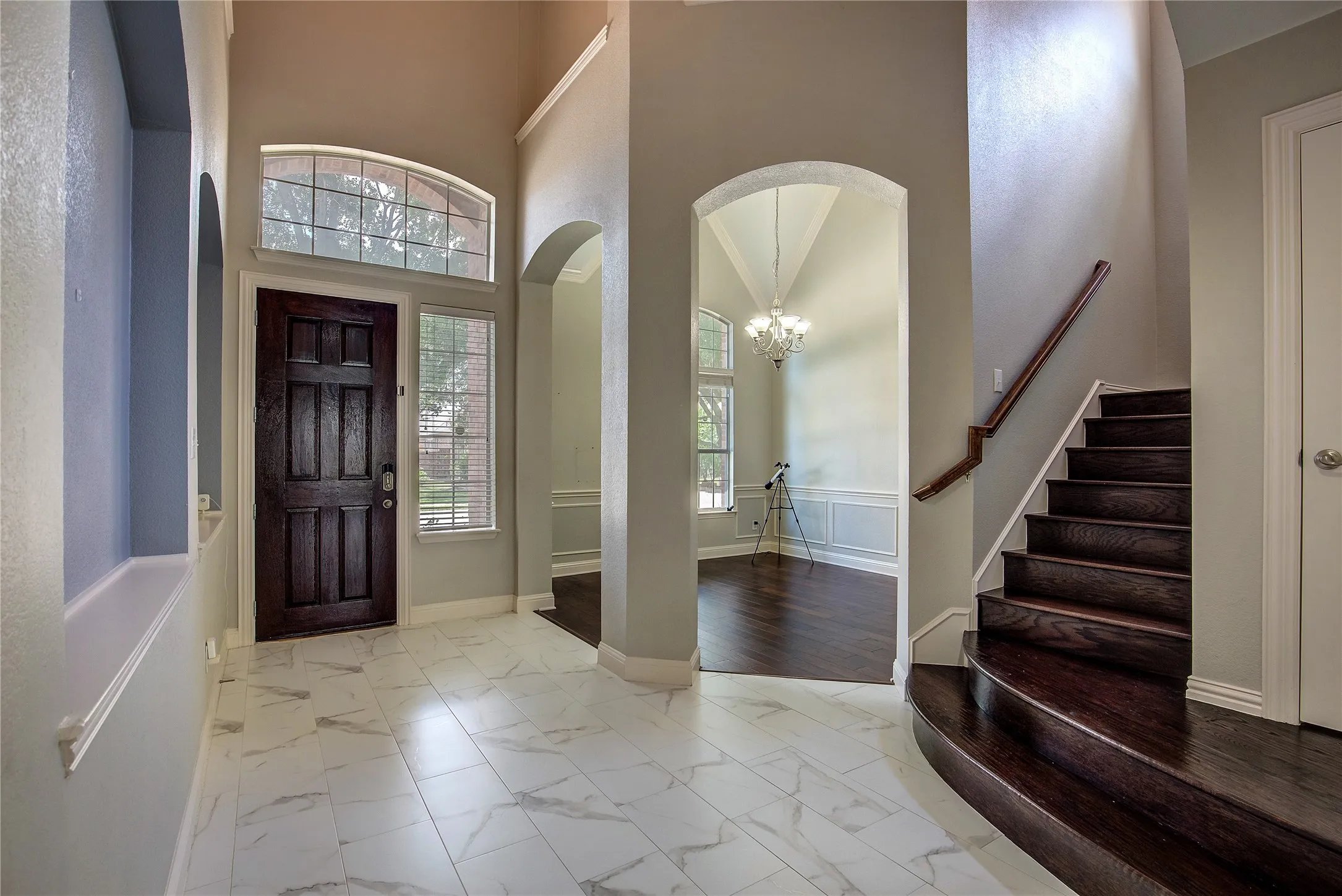 Entryway with light hardwood / wood-style flooring, an inviting chandelier, and a high ceiling