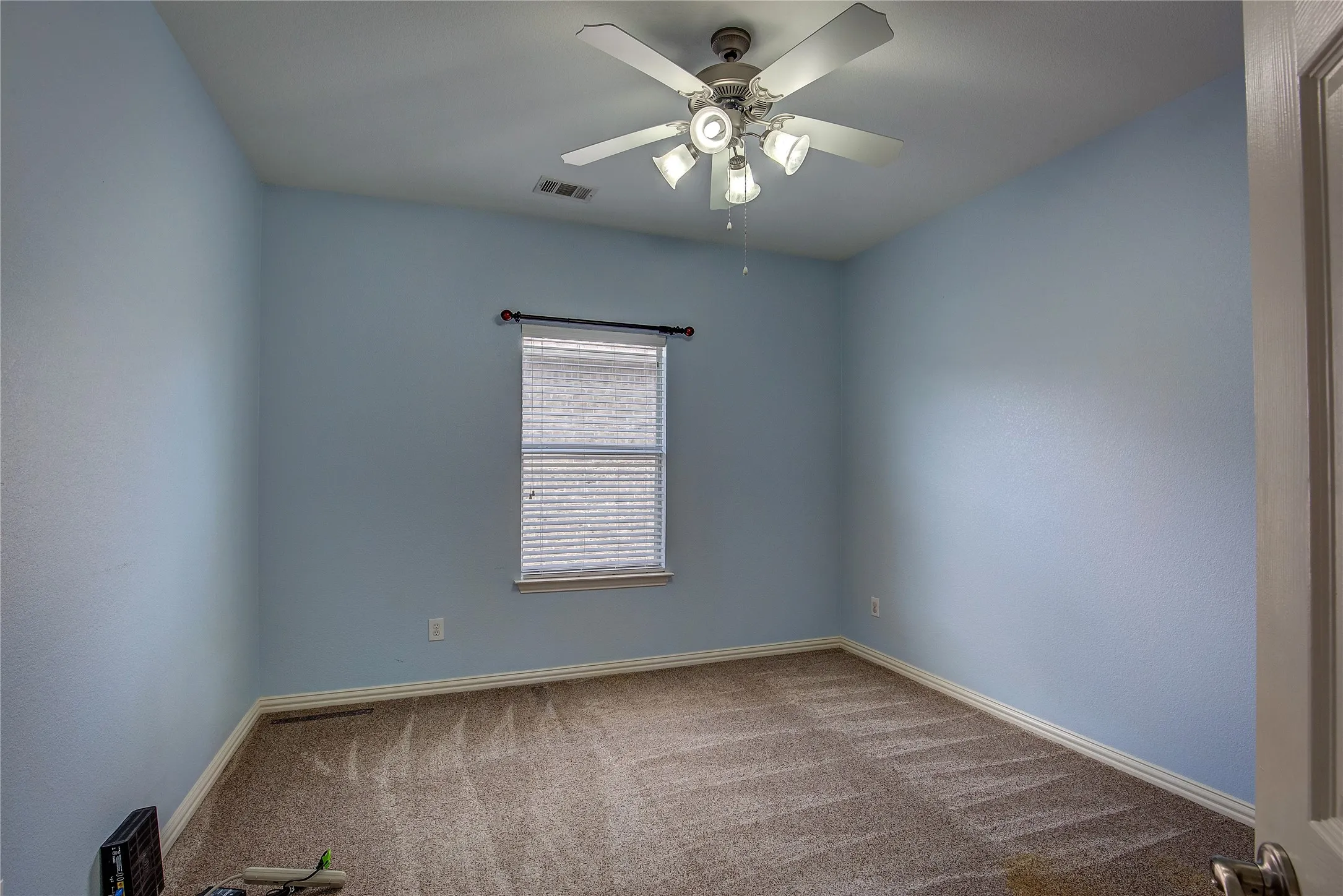 Carpeted spare room with ceiling fan