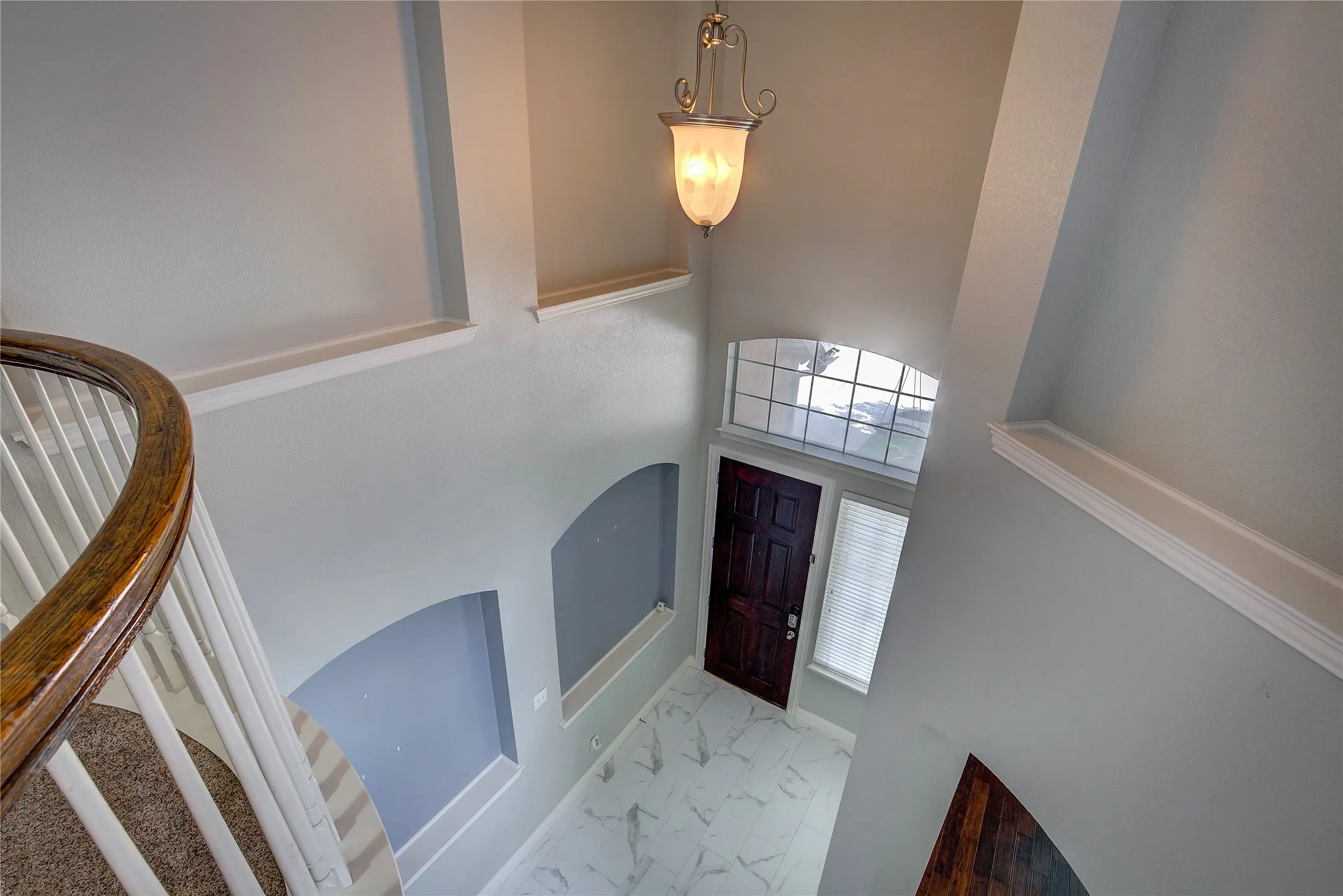 Tiled entryway featuring a towering ceiling