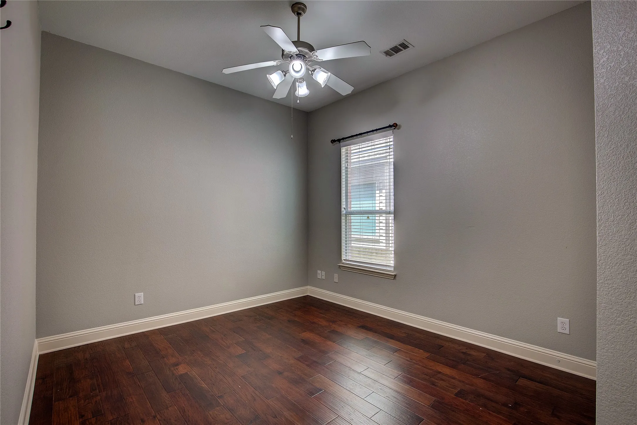 Spare room with hardwood / wood-style flooring and ceiling fan