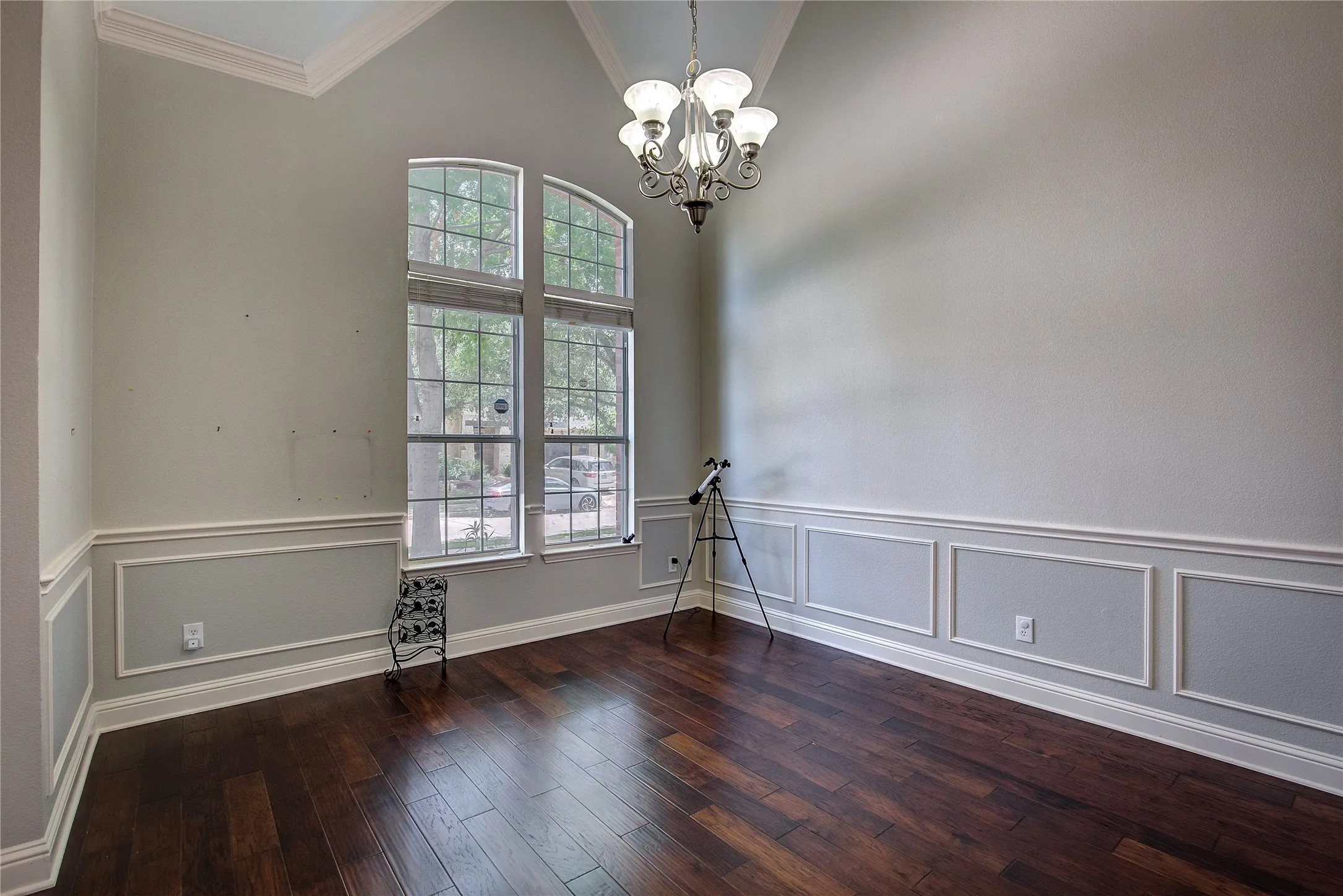 Unfurnished room with high vaulted ceiling, a chandelier, dark hardwood / wood-style flooring, and ornamental molding