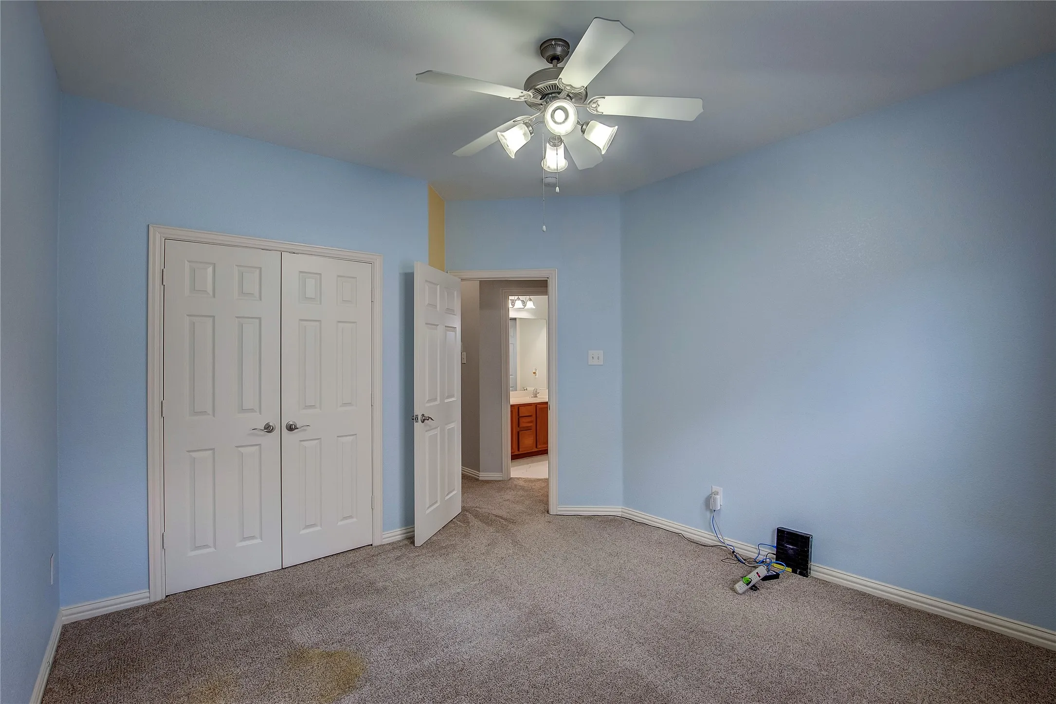 Unfurnished bedroom featuring carpet floors, ceiling fan, and a closet