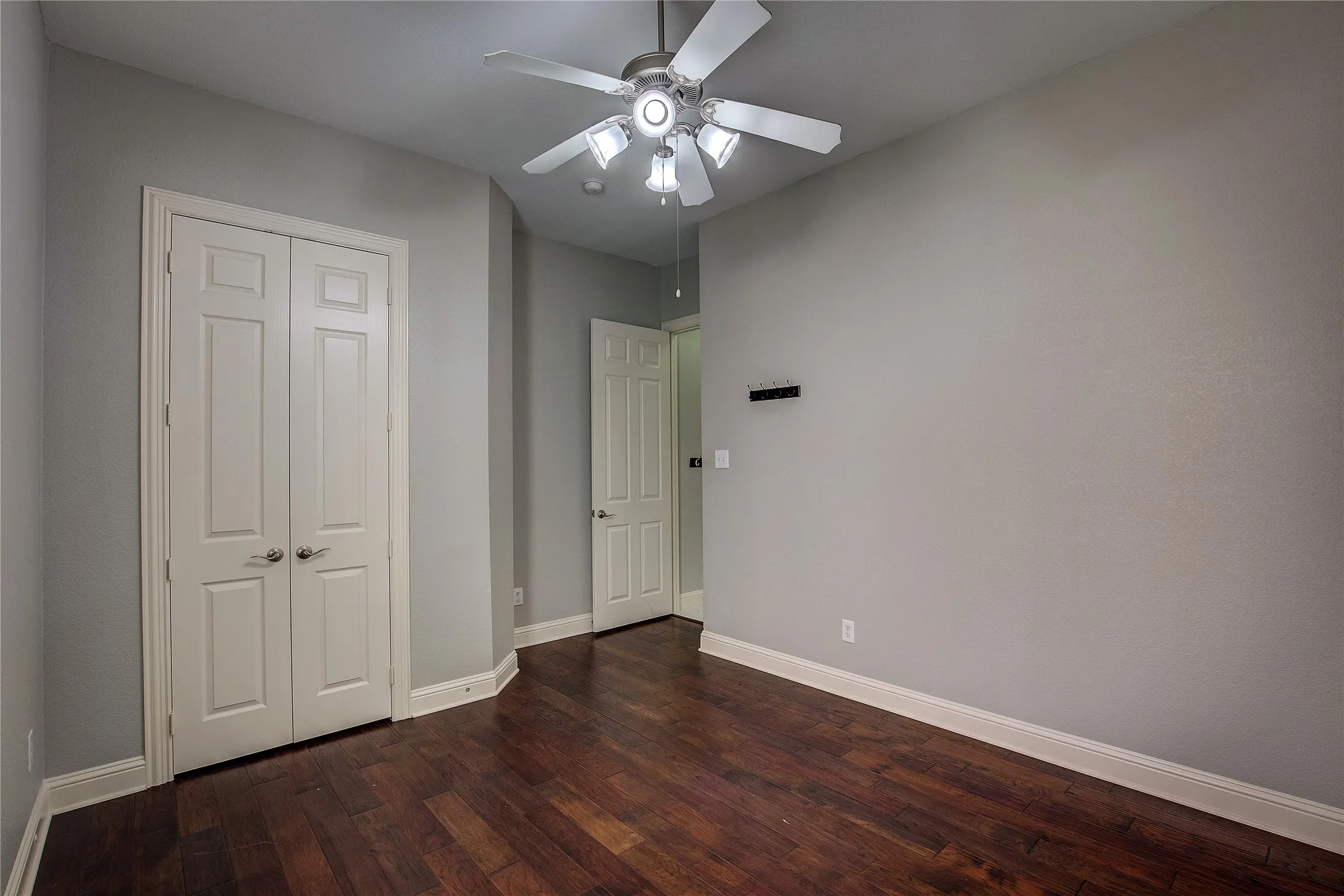 Unfurnished bedroom with hardwood / wood-style flooring, a closet, and ceiling fan