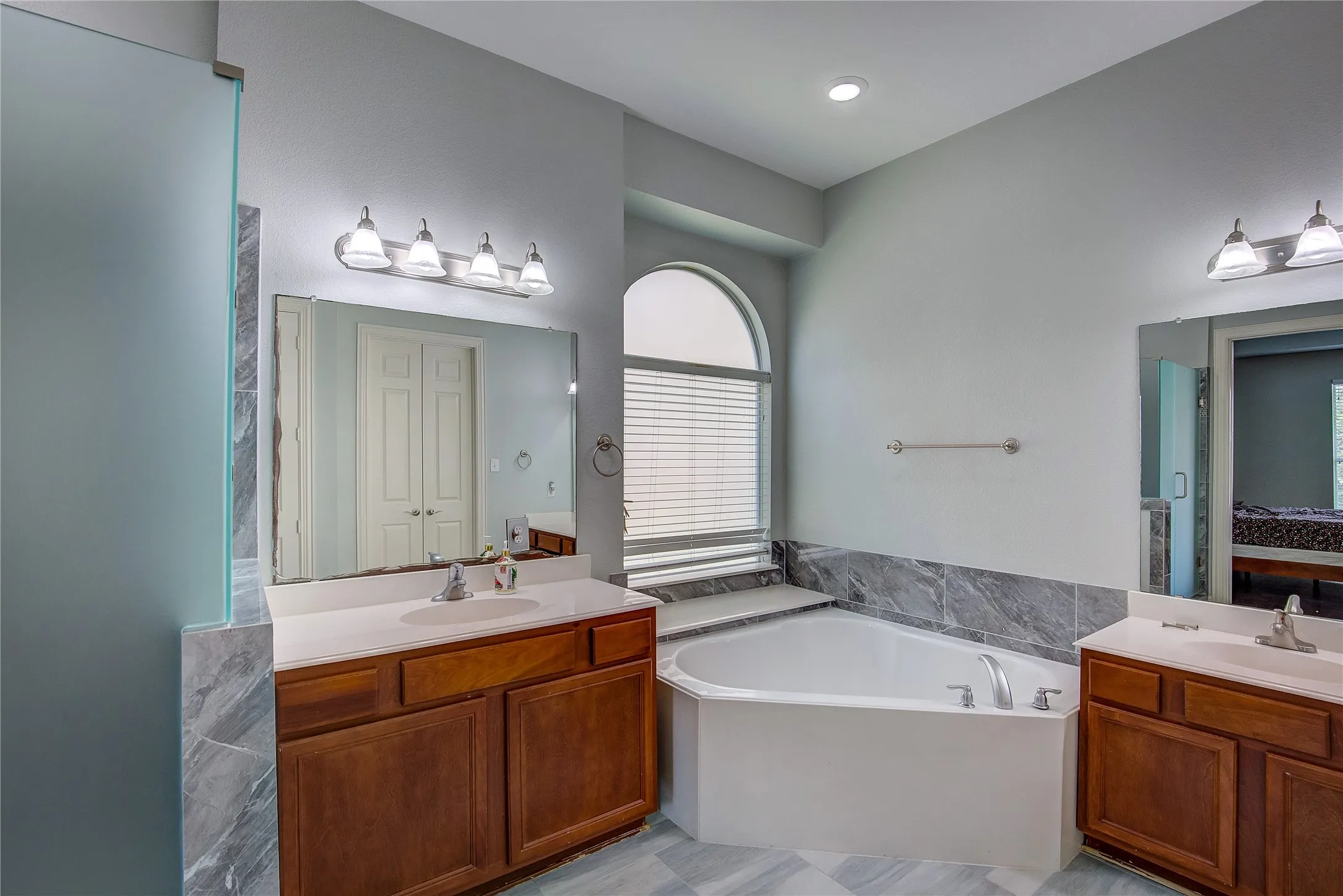 Bathroom with tile patterned flooring, double sink vanity, and a bathtub