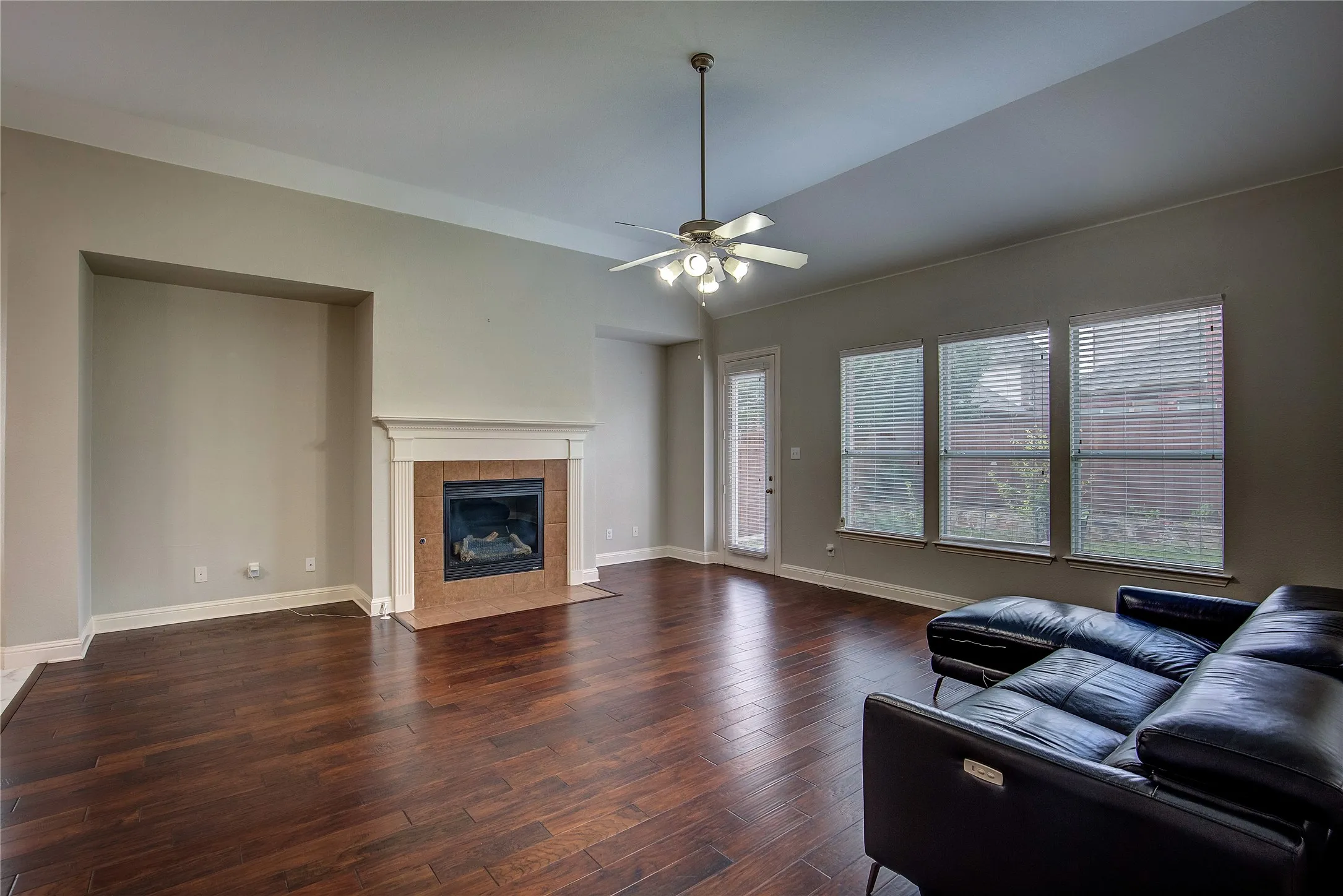 Living room with a fireplace, dark hardwood / wood-style floors, and ceiling fan