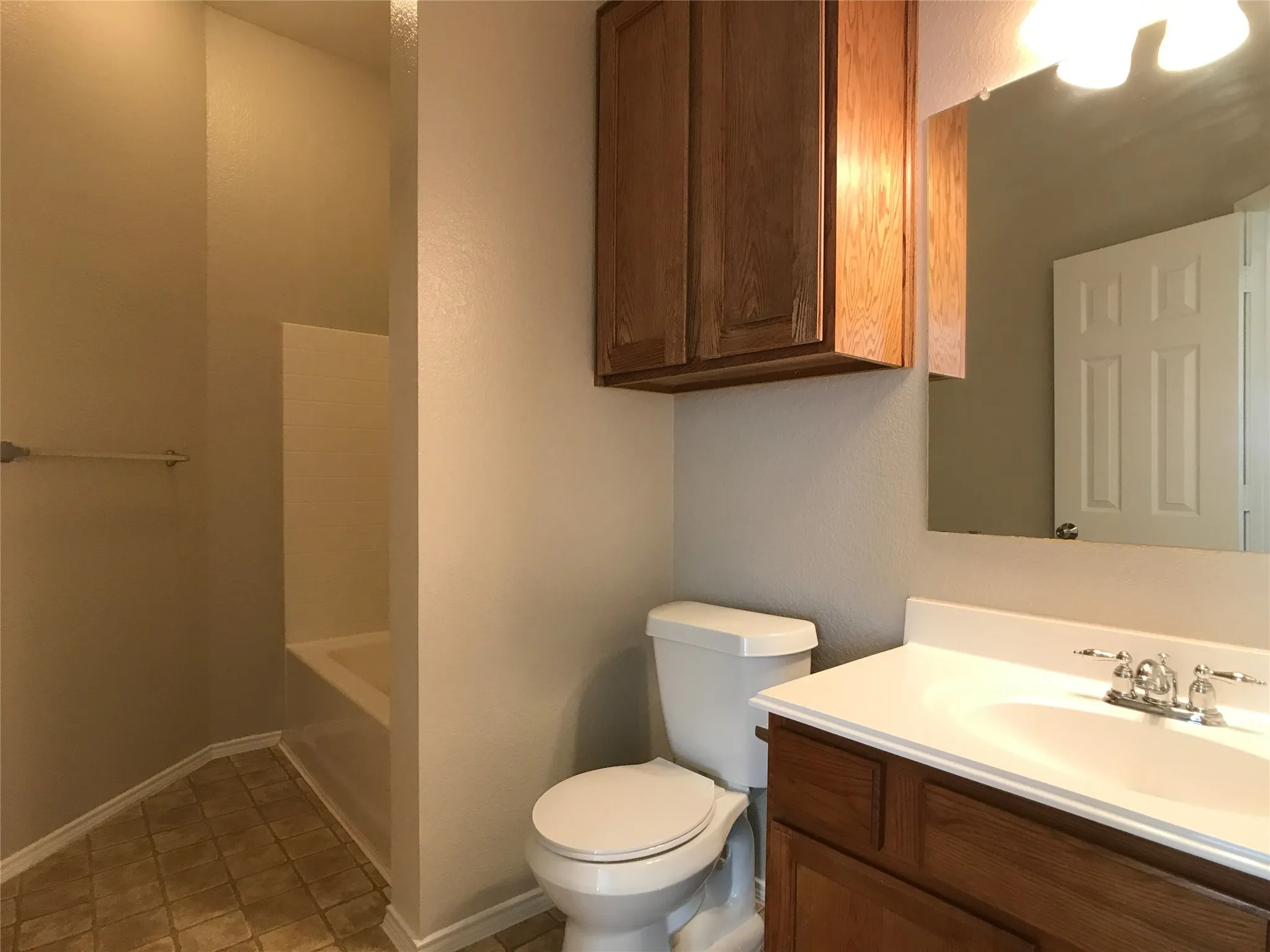 Bathroom featuring a single vanity with wood cabinetry, a white countertop, and a chrome faucet