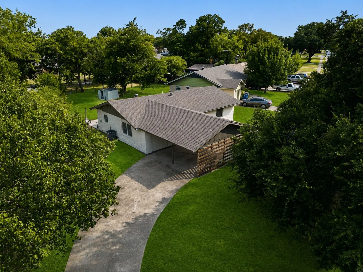 From above, this beautifully updated home showcases  its impressive footprint on a  generously sized lot surrounded by mature trees and established landscaping