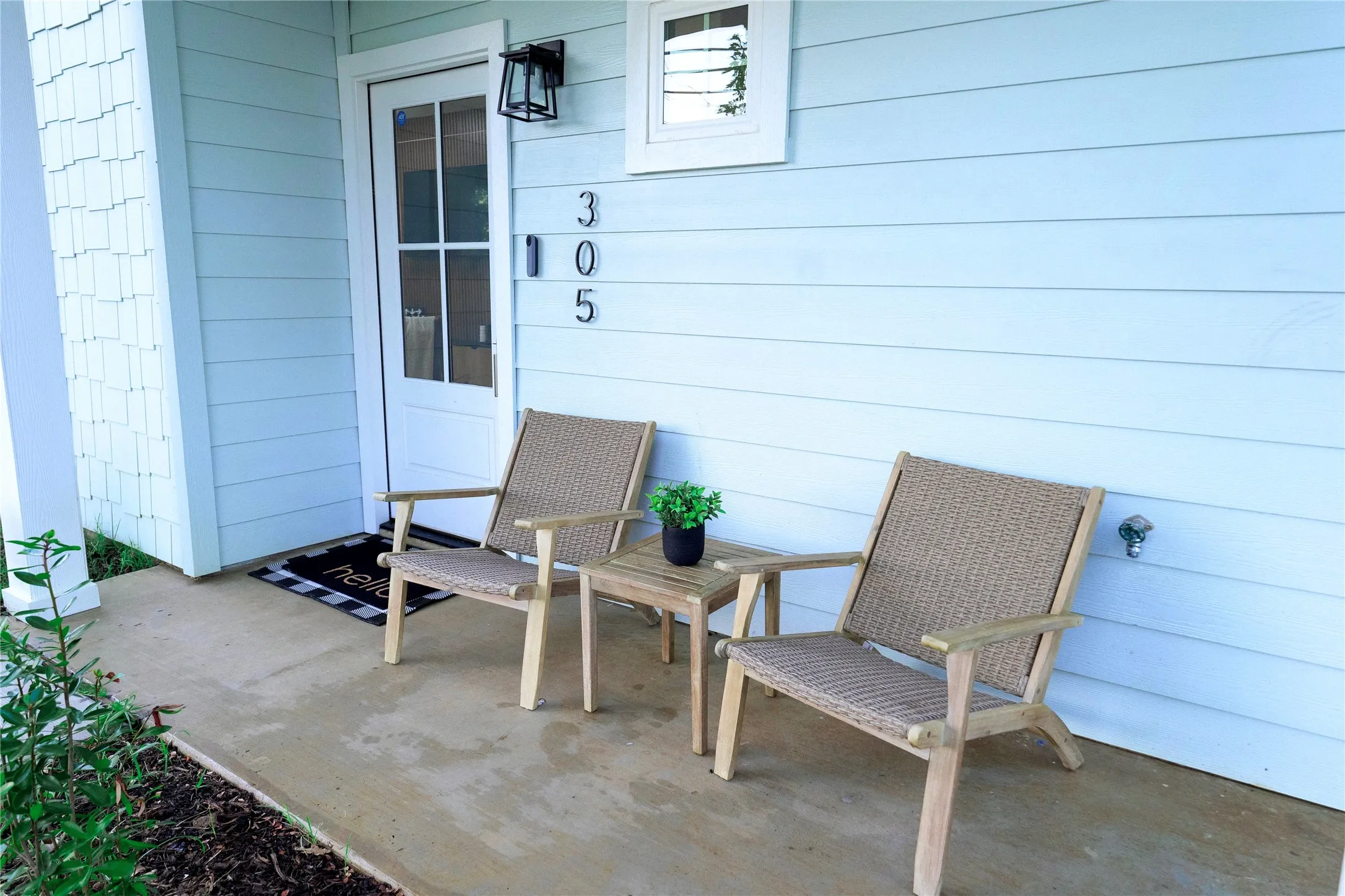 Light blue horizontal siding with welcoming front entry featuring white-trimmed glass door and transom window