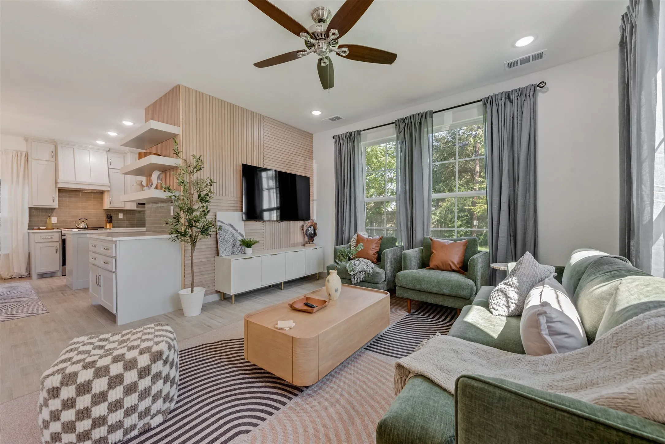 Open-concept living space featuring wood-finish flooring, recessed lighting, and a ceiling fan
