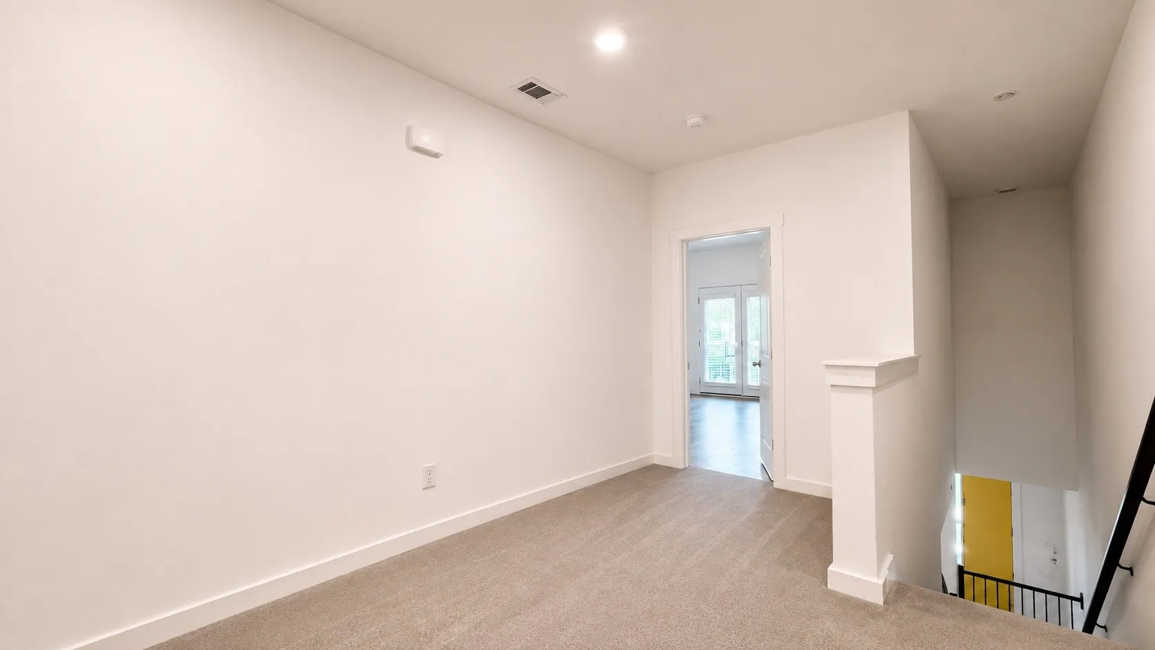 Bright, open room featuring neutral wall finishes, recessed ceiling lighting, and wood-finish flooring throughout