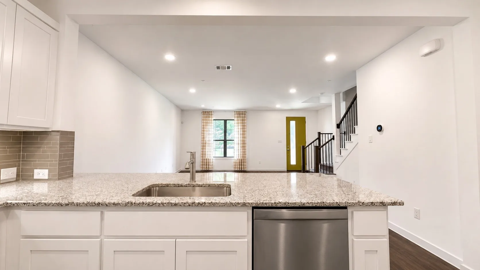 Kitchen island with granite countertop, undermount stainless steel sink, and stainless steel dishwasher