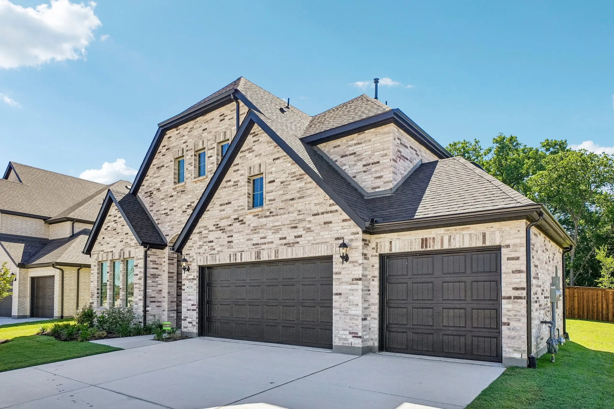 With neutral brick and striking dark trim, this dream home offers a 3 car garage and tons of curb appeal!