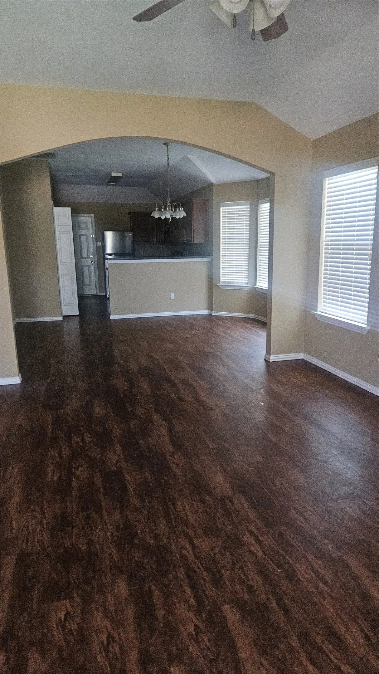 Wood-finish flooring, vaulted ceiling, and arched entryway