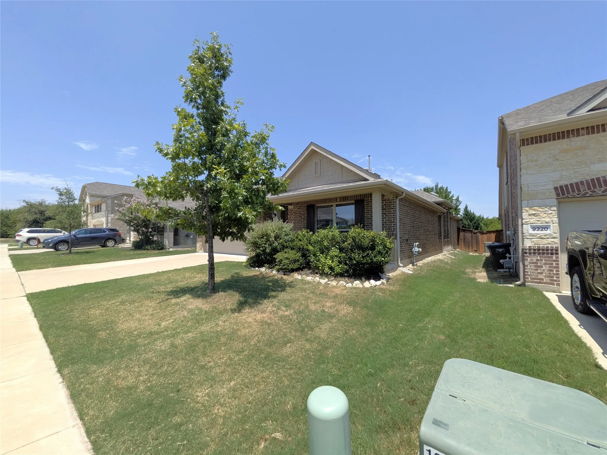 Charming brick home situated on a spacious lot featuring a mature shade tree, manicured lawn, and attached garage