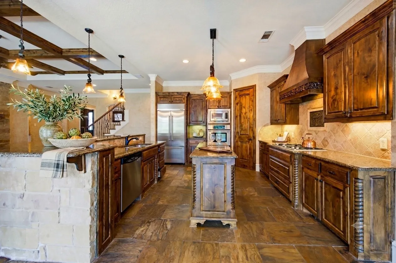 Virtually staged. Gourmet kitchen featuring rich wood cabinetry, stainless steel appliances, and a generous center island with seating