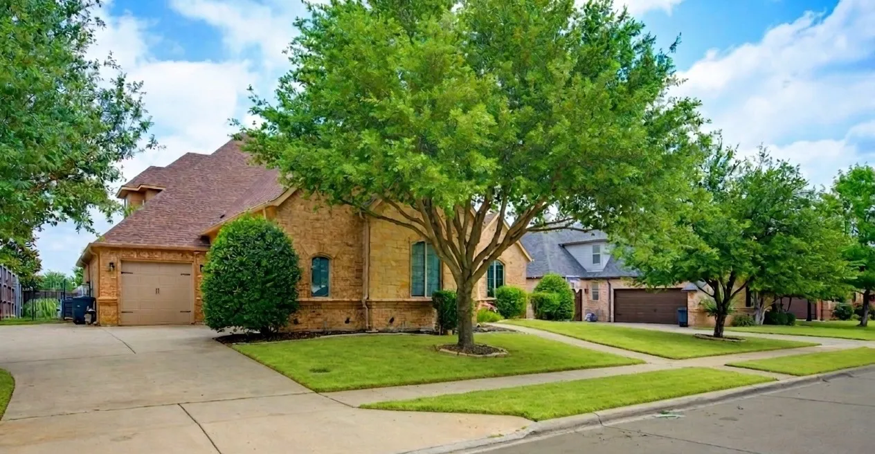 Charming brick residence with a three-car garage, mature landscaping, and expansive driveway