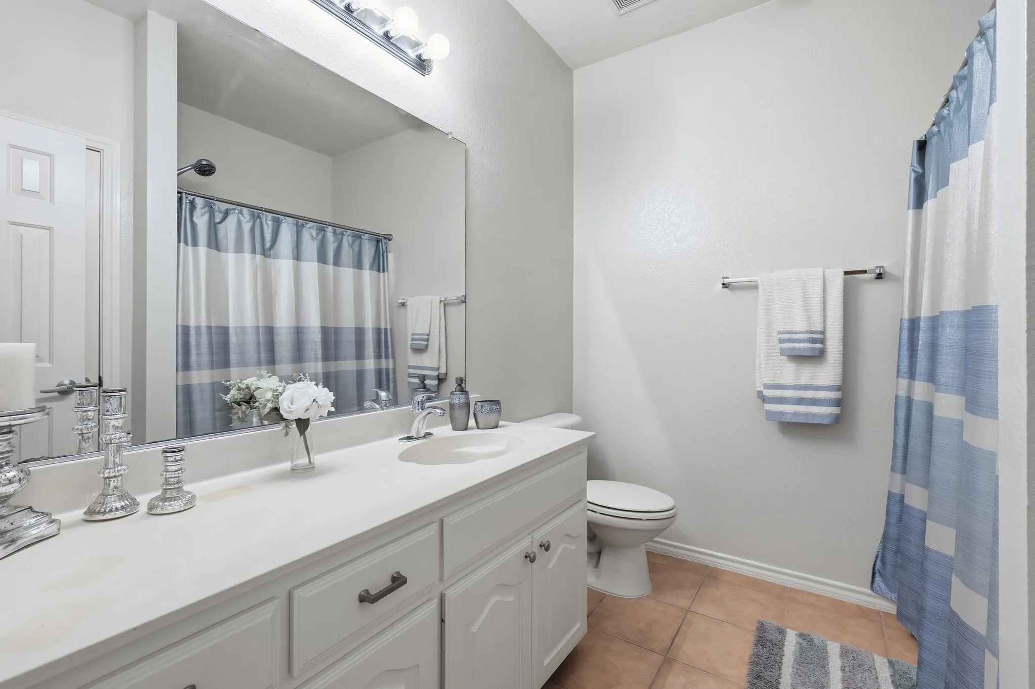 Full vanity with integrated sink, chrome faucet, and expansive mirror
