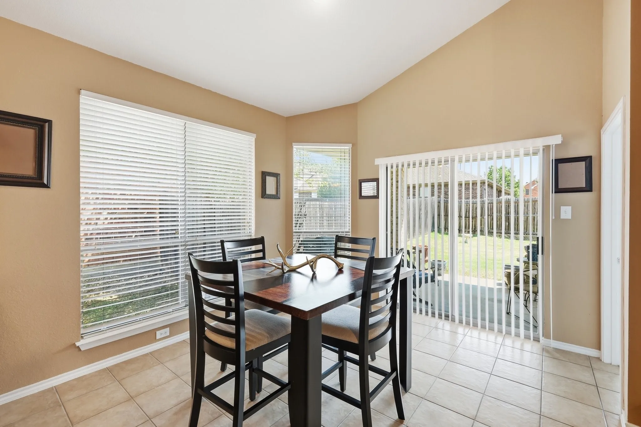 Vaulted ceiling dining space featuring ceramic tile flooring