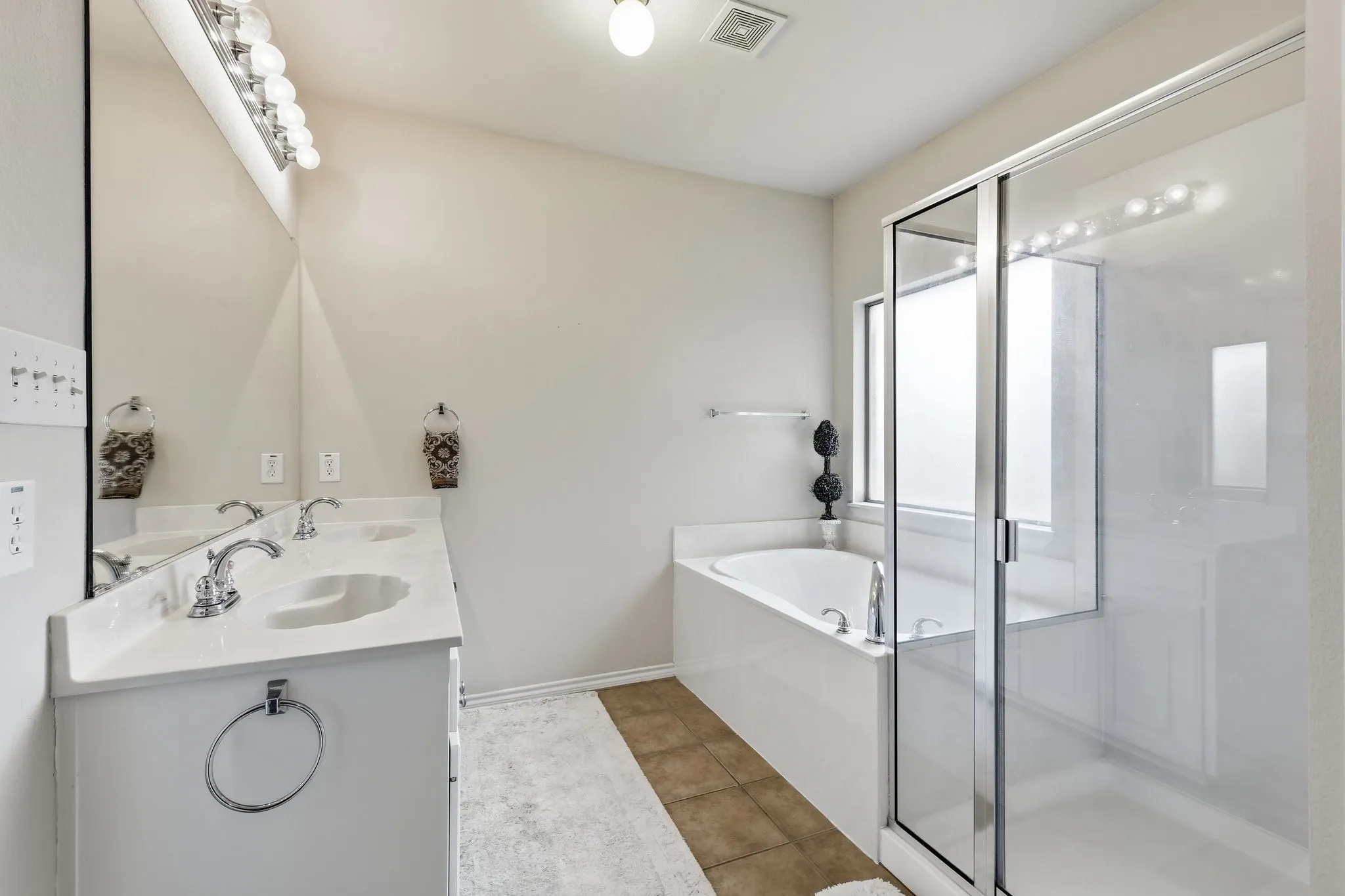 Dual vanity with undermount sinks, chrome fixtures, and a large mirror