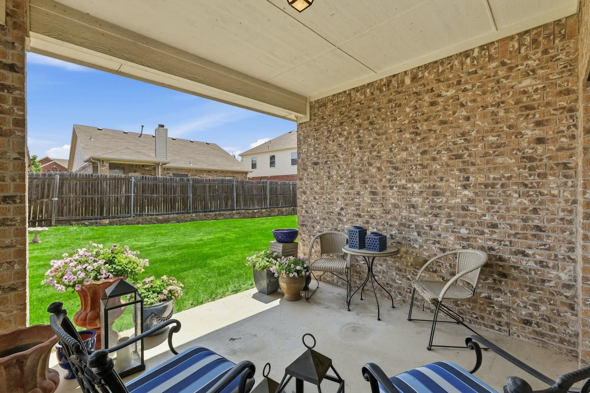 Covered patio featuring a concrete slab and brick exterior wall