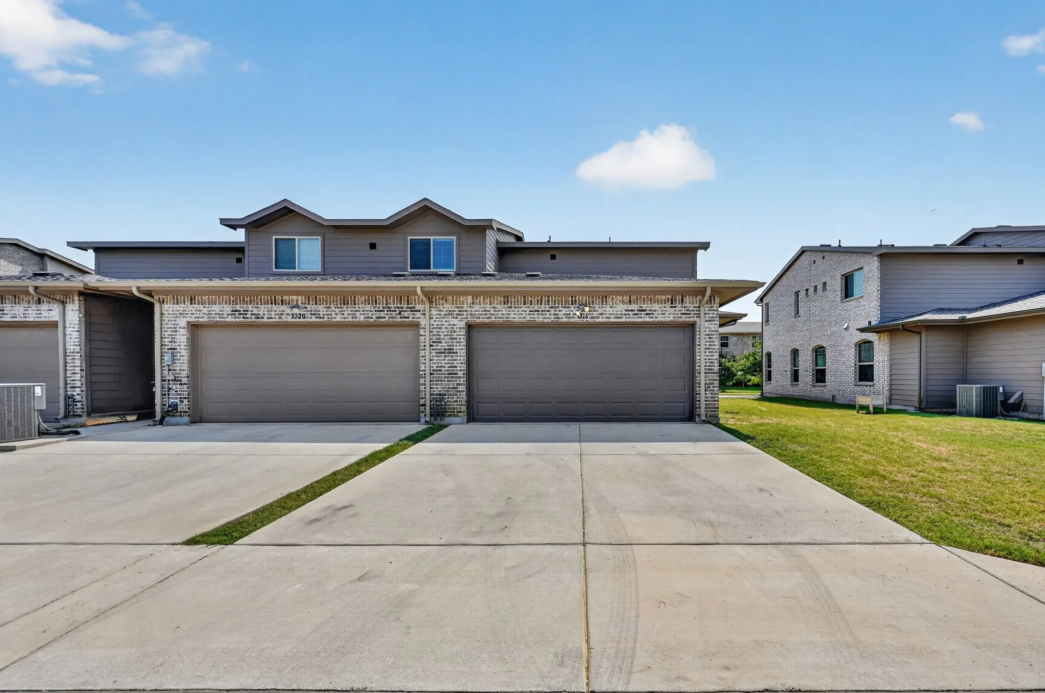 Contemporary townhome architecture featuring brick and siding facades