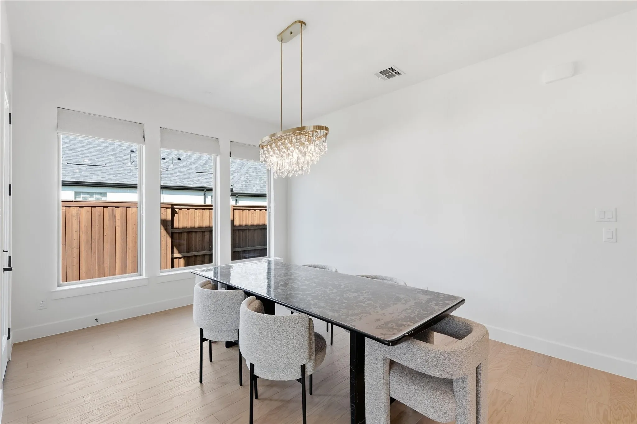 Recessed lighting, wood-finish flooring, and multiple windows with roller shades
