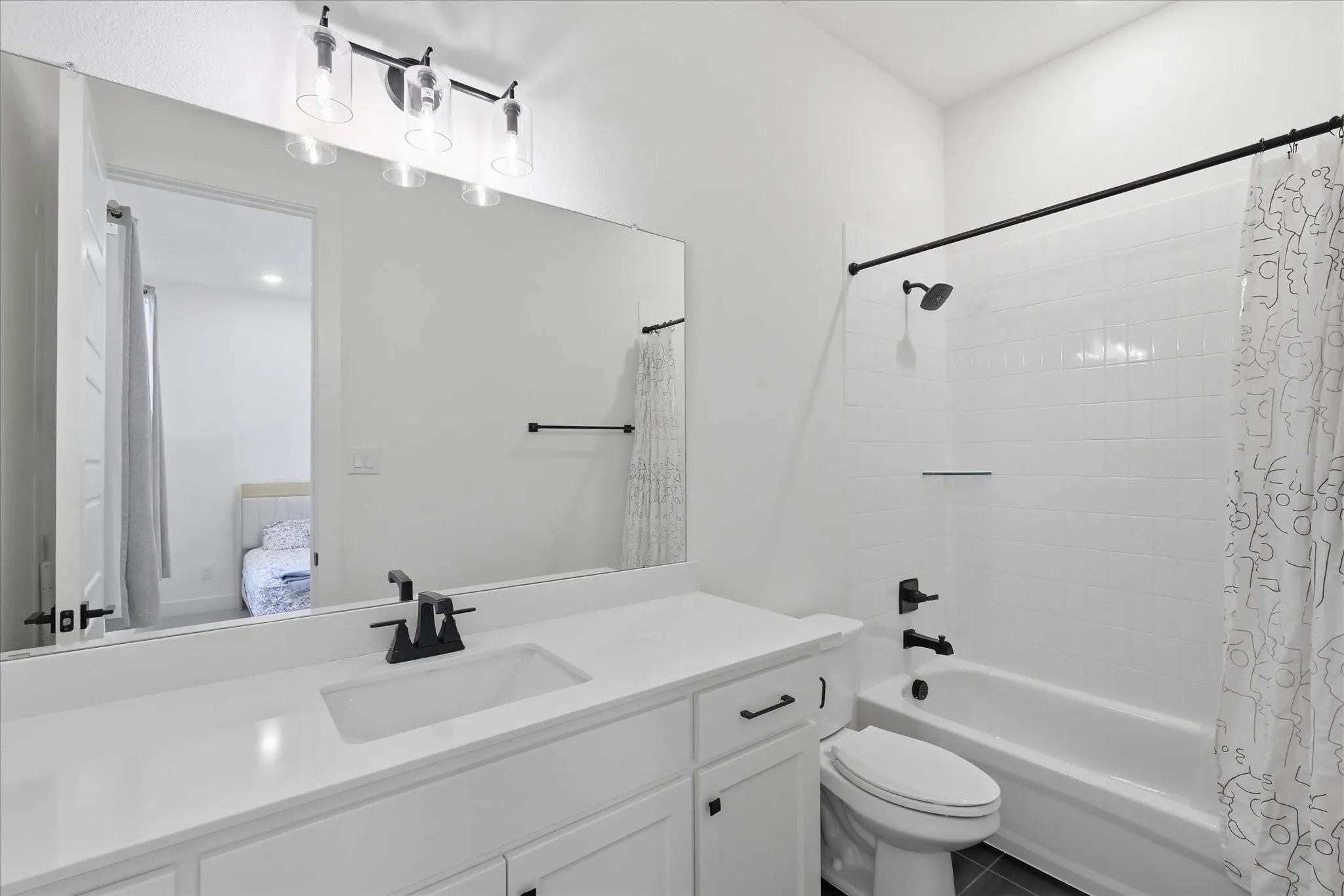 Modern bathroom featuring dual vanity with white quartz countertop, undermount sinks, and matte black fixtures