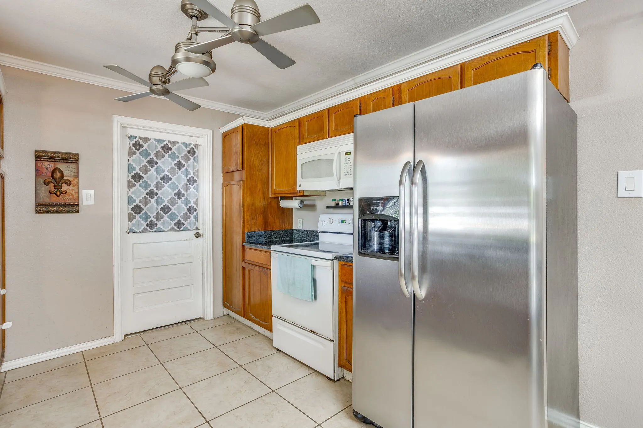 Kitchen featuring a stainless steel side-by-side refrigerator, white range, and white built-in microwave