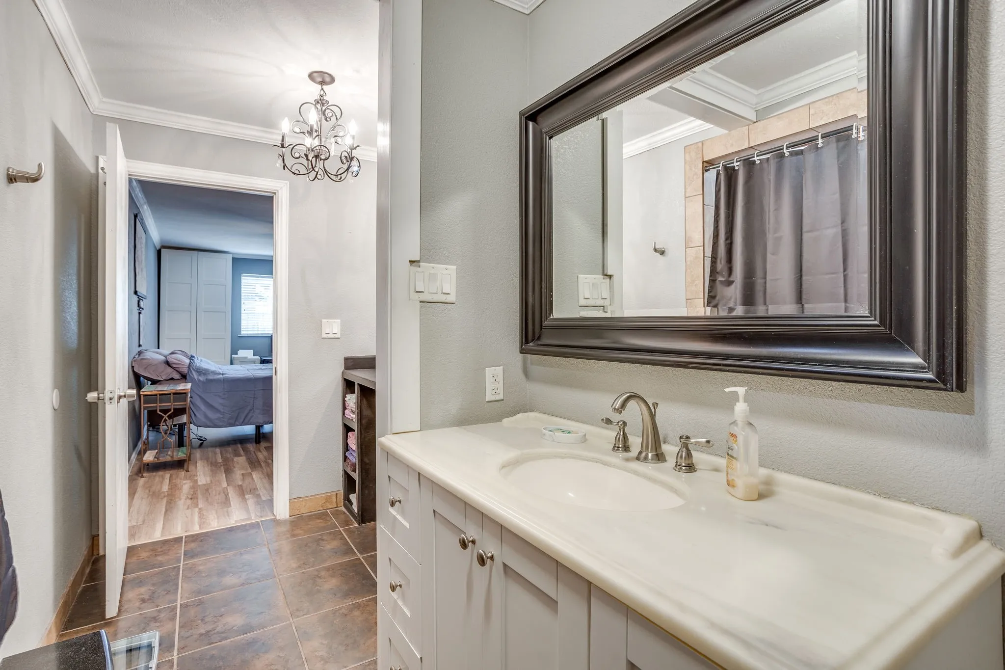 Elegant master bathroom featuring a spacious dual-sink vanity with white cabinetry, quartz countertop, and brushed nickel fixtures
