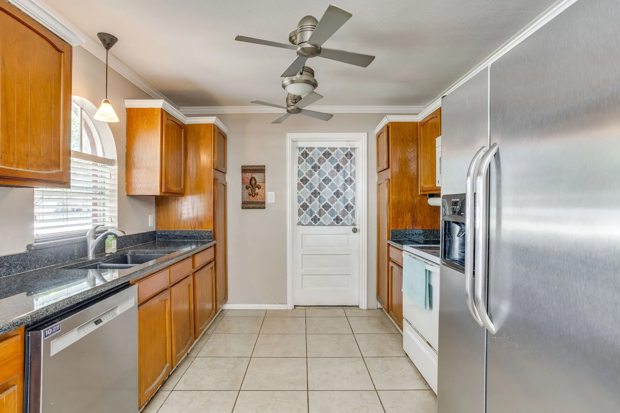 Kitchen featuring wood cabinetry, dark countertops, and stainless steel appliances