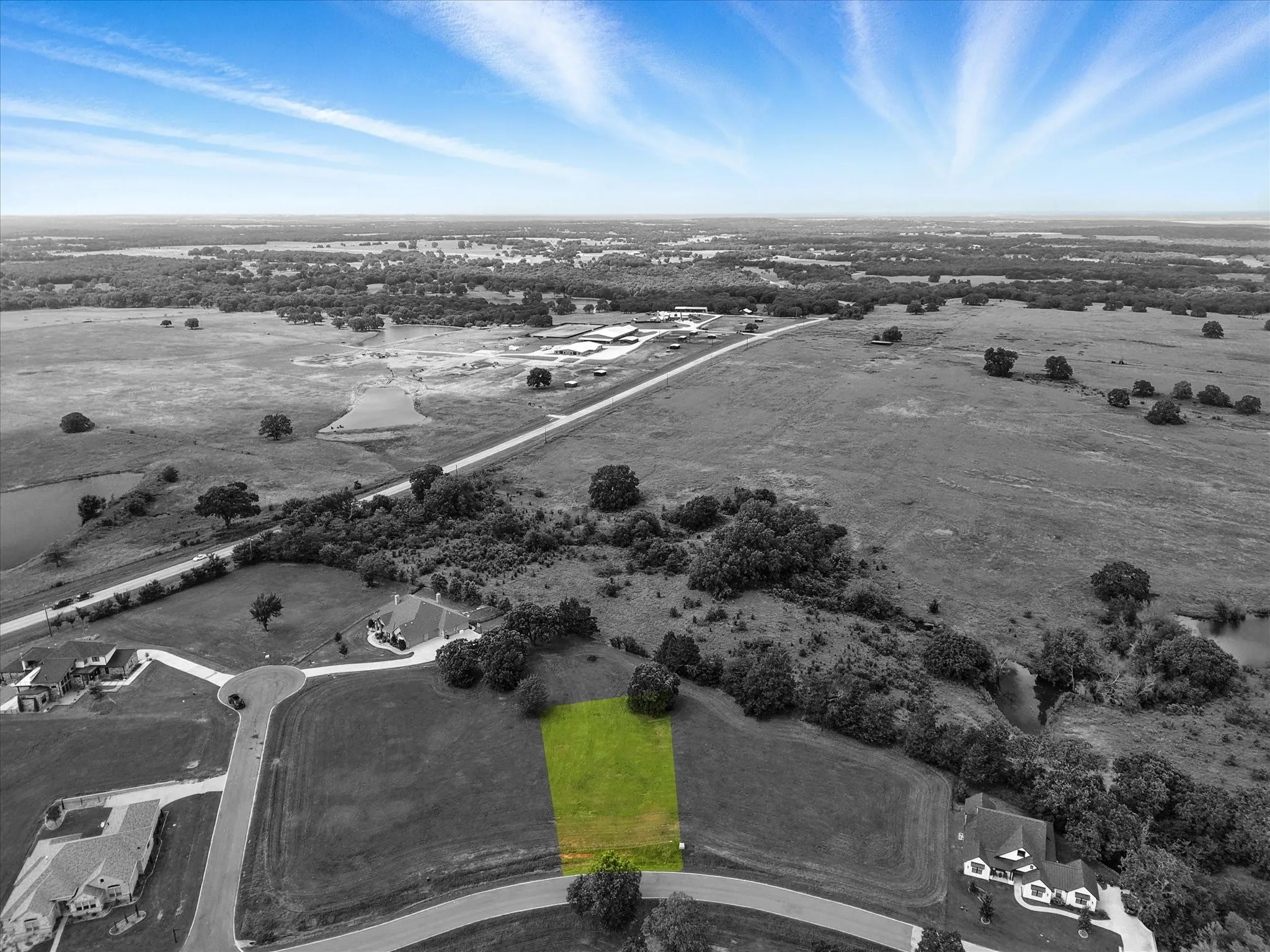 Aerial view showcasing a distinctive highlighted parcel situated within expansive agricultural acreage