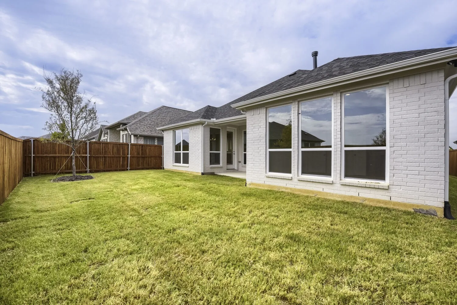 Expansive grass lawn with a wood privacy fence