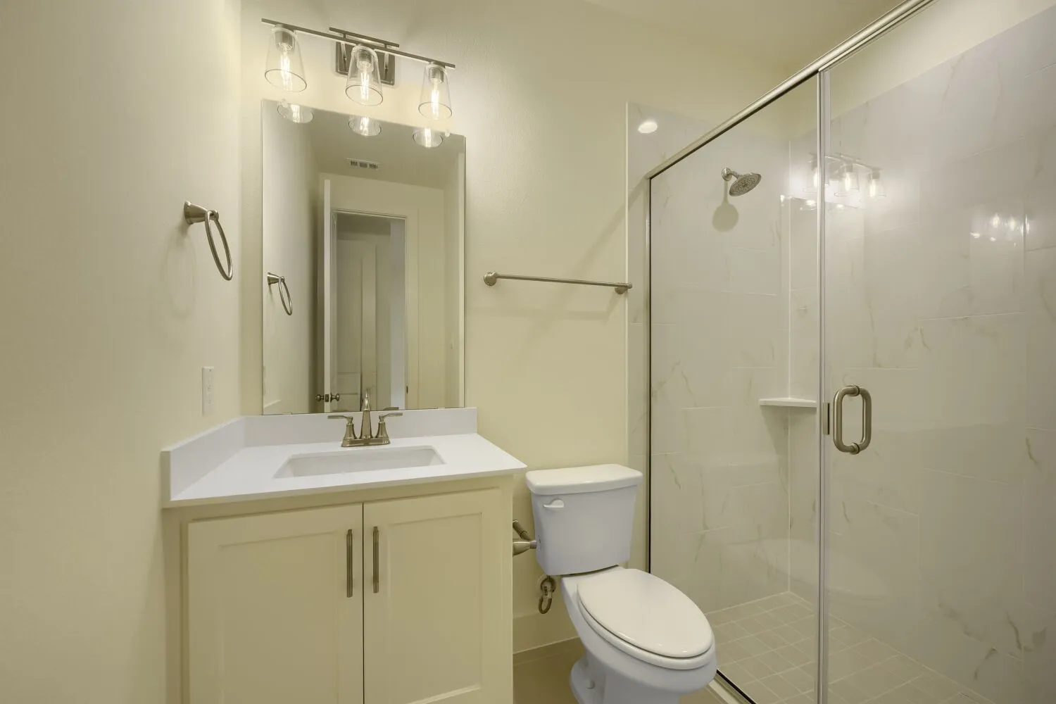 White vanity with a single basin, brushed nickel faucet, and integrated mirror