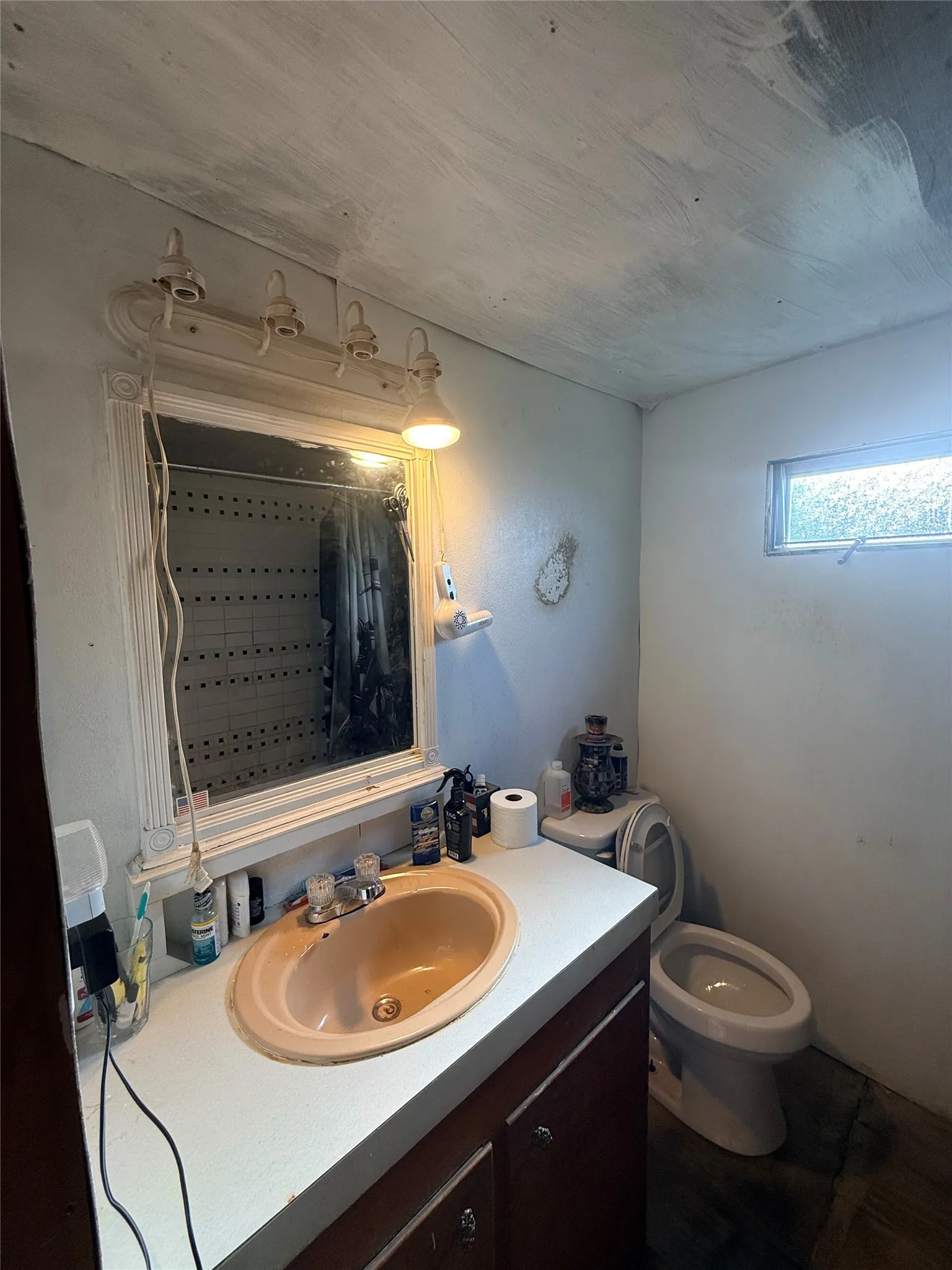Bathroom vanity featuring an oval drop-in sink, laminate countertop, and wood-finish cabinetry