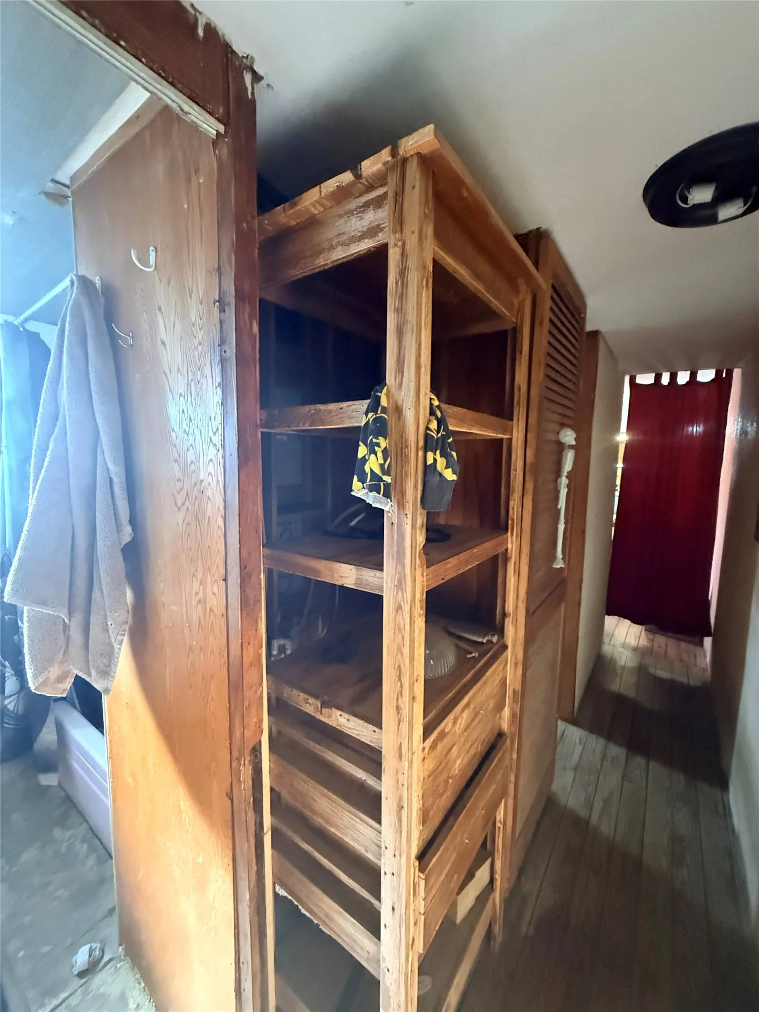 Wooden display cabinet with glass-front doors and multiple shelving levels, featuring louvered ventilation panels and brass hardware