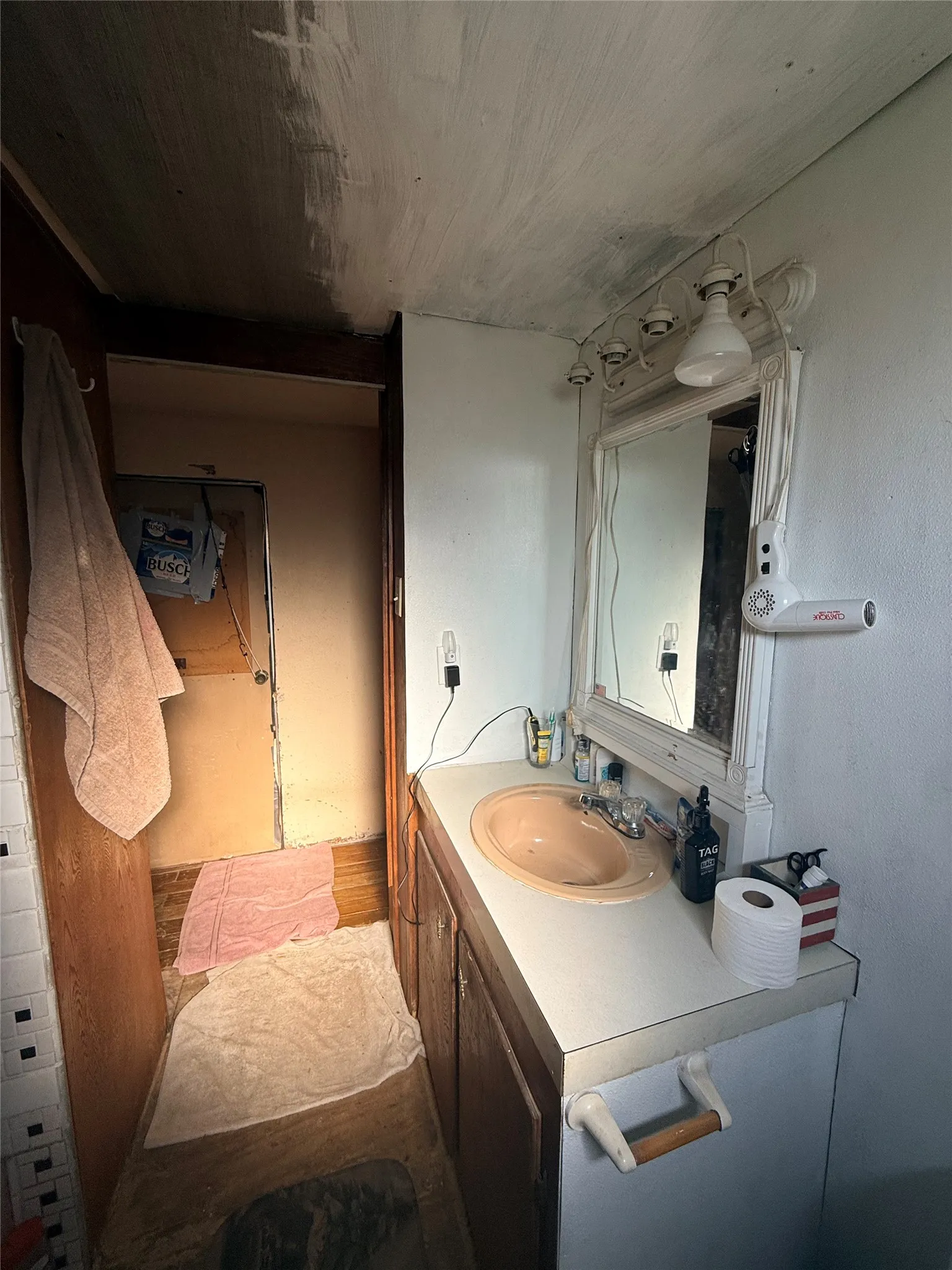 Bathroom featuring a white vanity with integrated sink, framed mirror with integrated lighting, and ceramic tile flooring