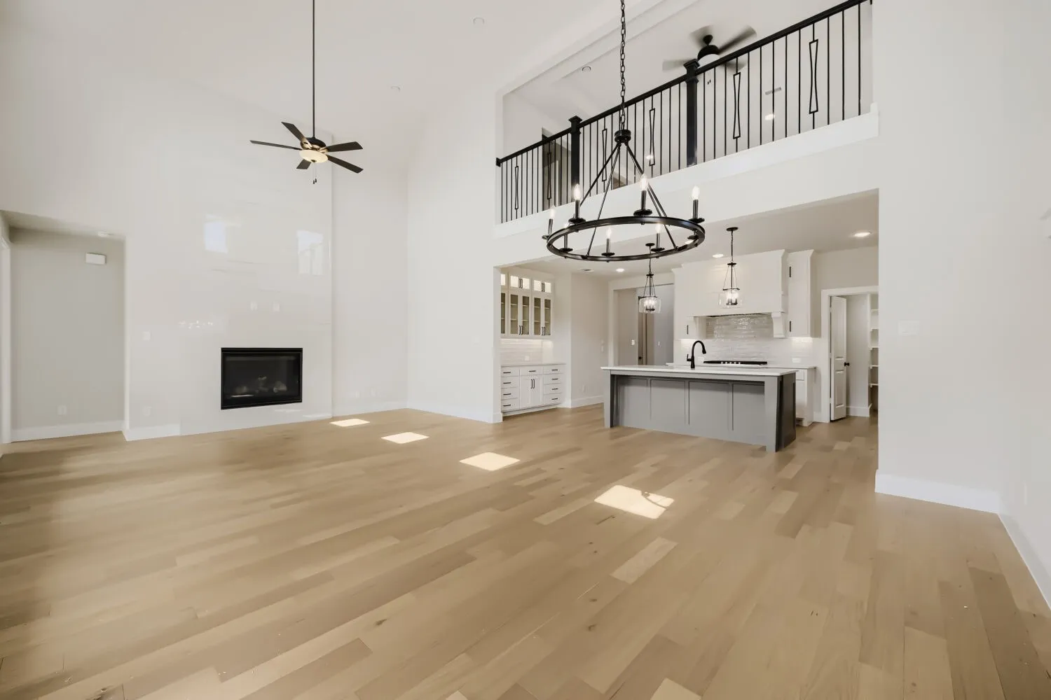 Vaulted ceilings, wood-finish flooring, and a contemporary fireplace with a sleek surround