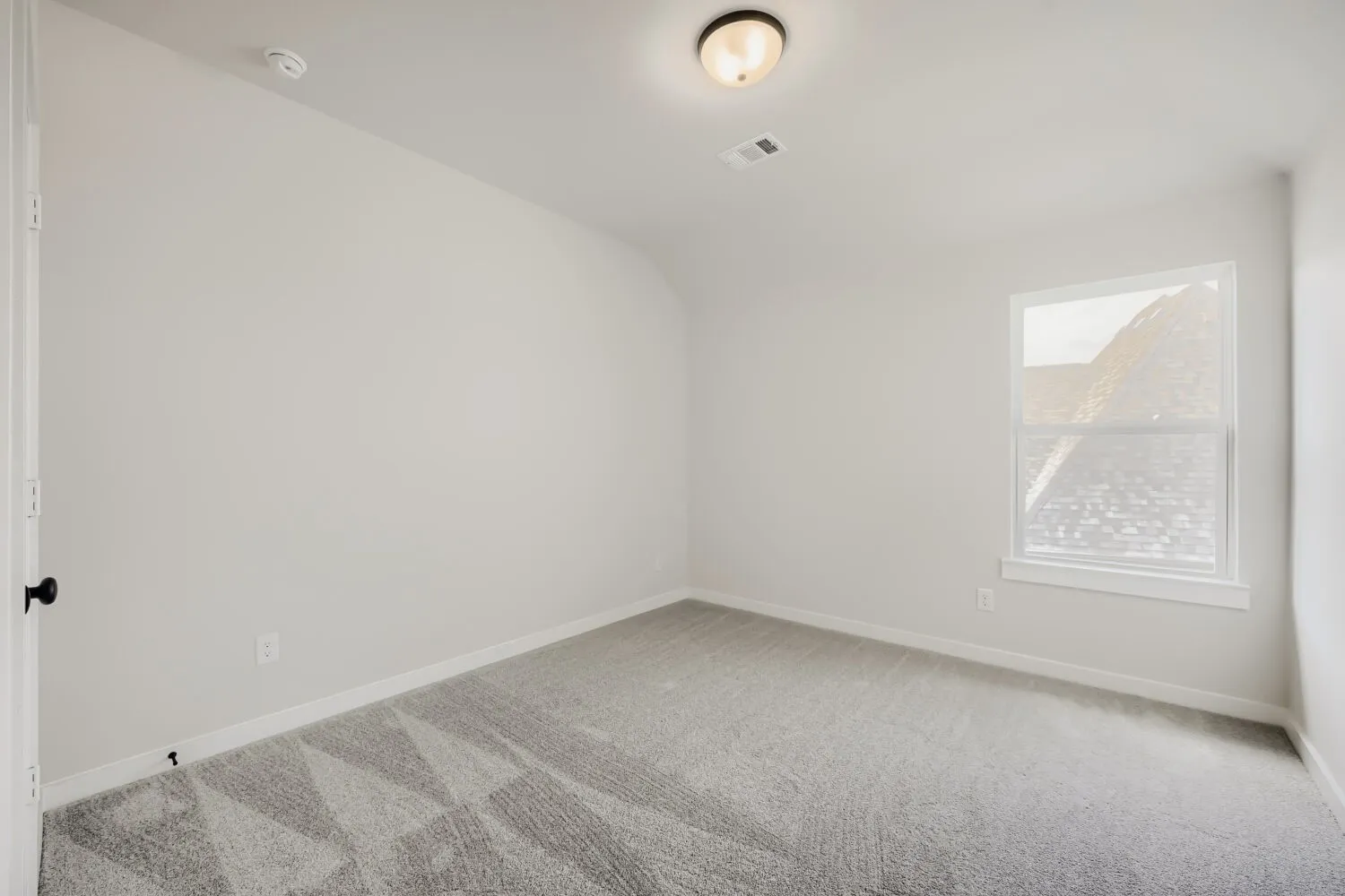 Neutral wall color, carpeted flooring, and a single window