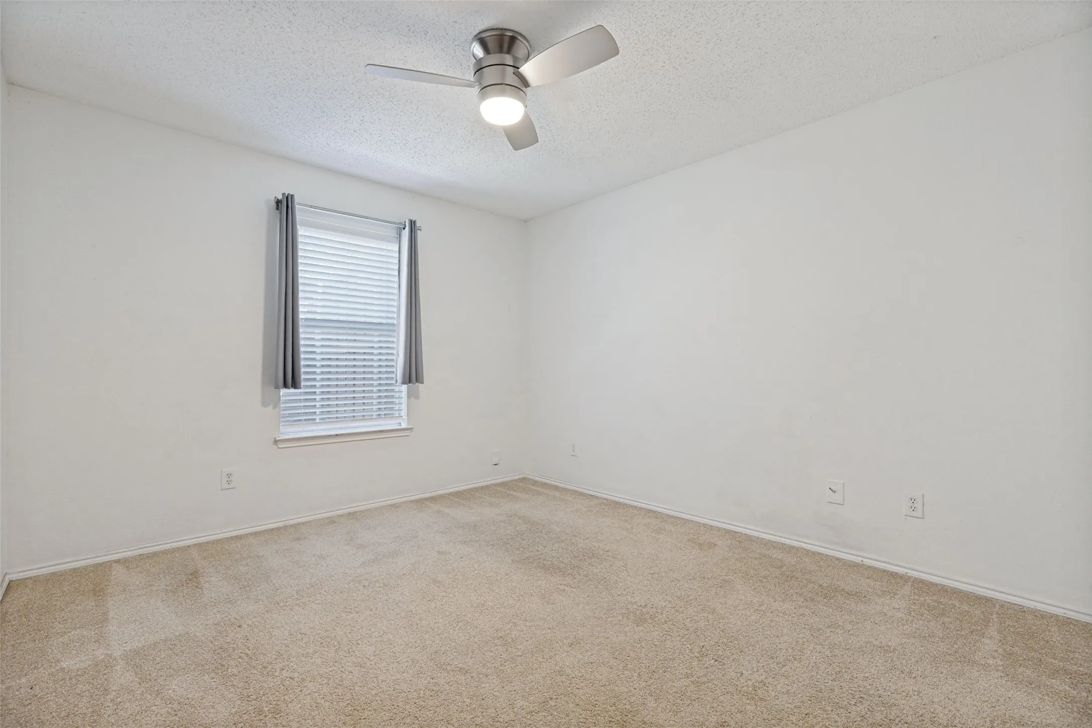 Recessed window with blinds, ceiling fan with integrated lighting, and carpeted flooring
