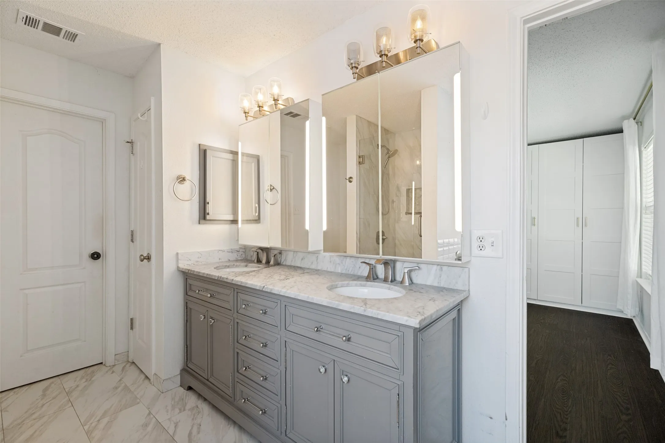 Dual vanity with gray cabinetry and stone countertop