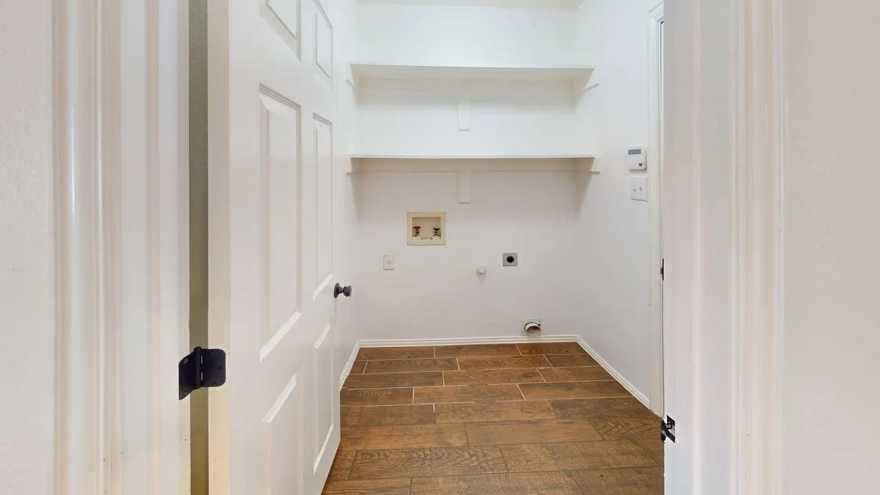Hallway featuring warm wood-finish flooring, white painted walls, and built-in shelving