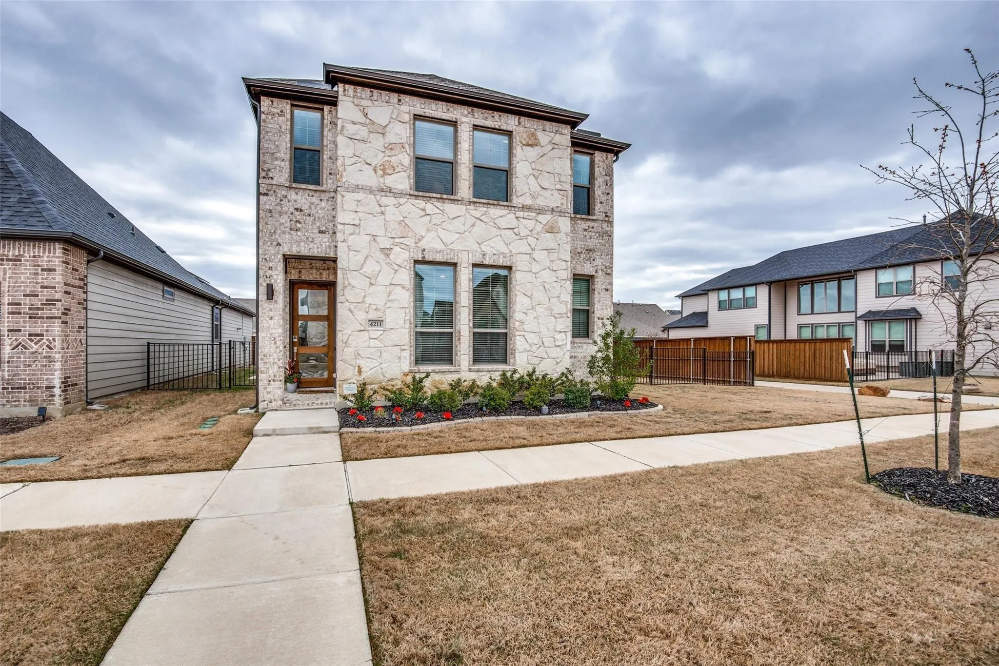 Modern two-story residence featuring a striking stone and brick exterior with clean architectural lines