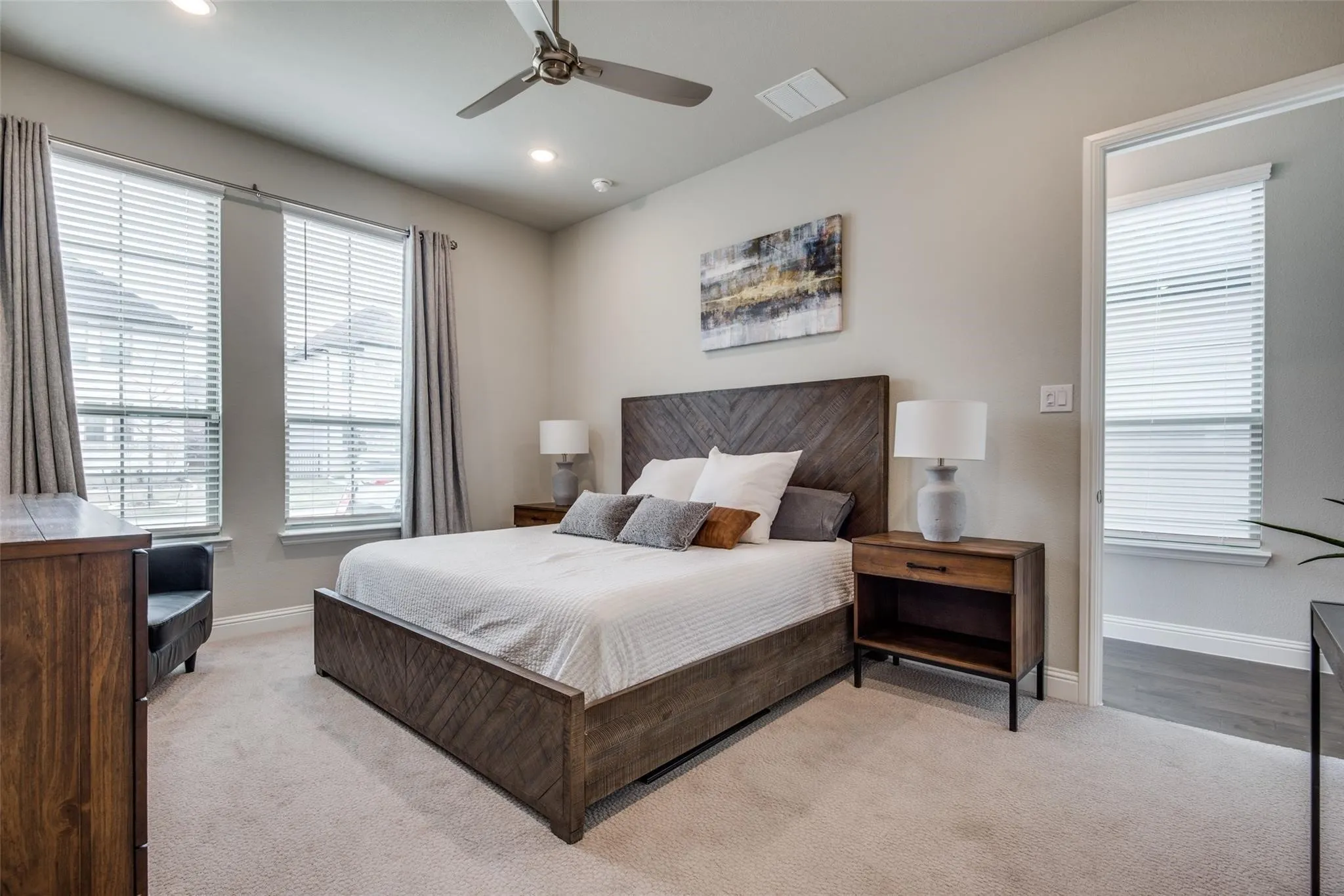 Carpeted room featuring recessed lighting, a ceiling fan, and two windows with blinds and drapes