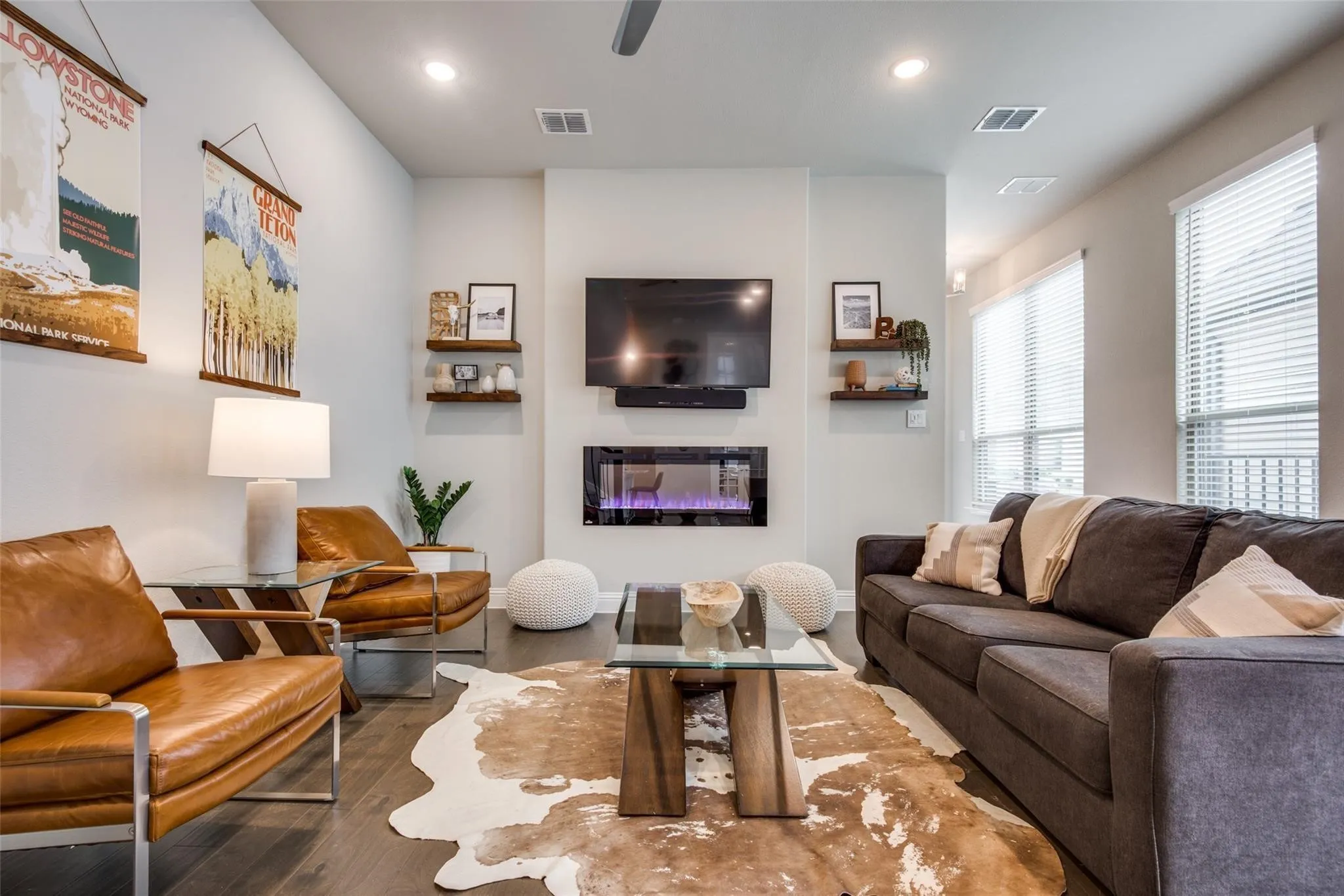 Contemporary living room featuring a gas fireplace with built-in shelving, recessed ceiling lighting, and large windows with plantation shutters